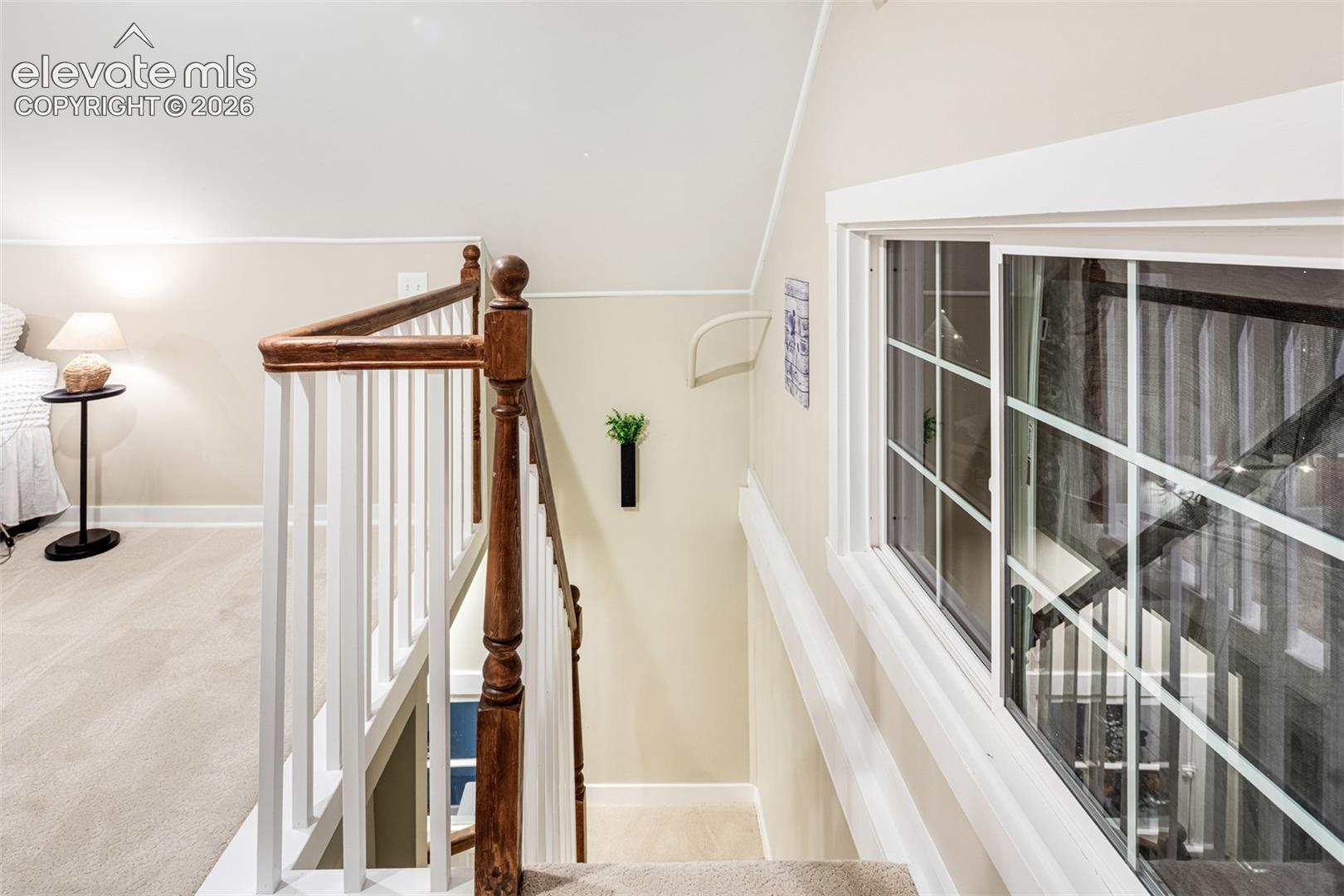 White baluster railing with a polished wood-finish handrail