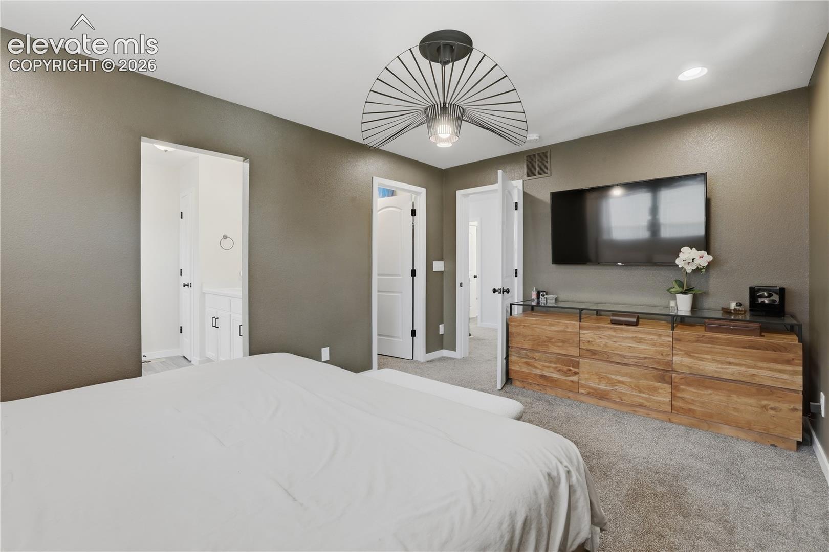 Carpeted bedroom featuring an overhead ceiling fixture, recessed lighting, and a neutral wall color