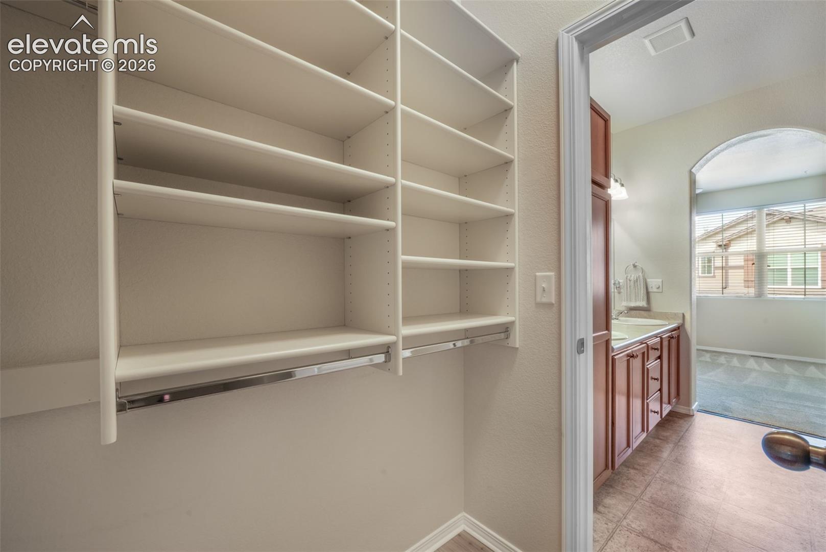 Built-in shelving, integrated closet rods, and an arched entry