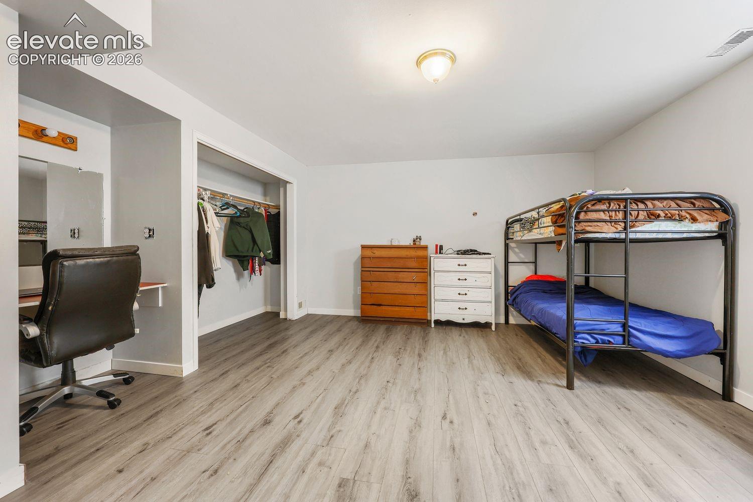Room featuring wood-finish flooring, recessed lighting, and a built-in closet