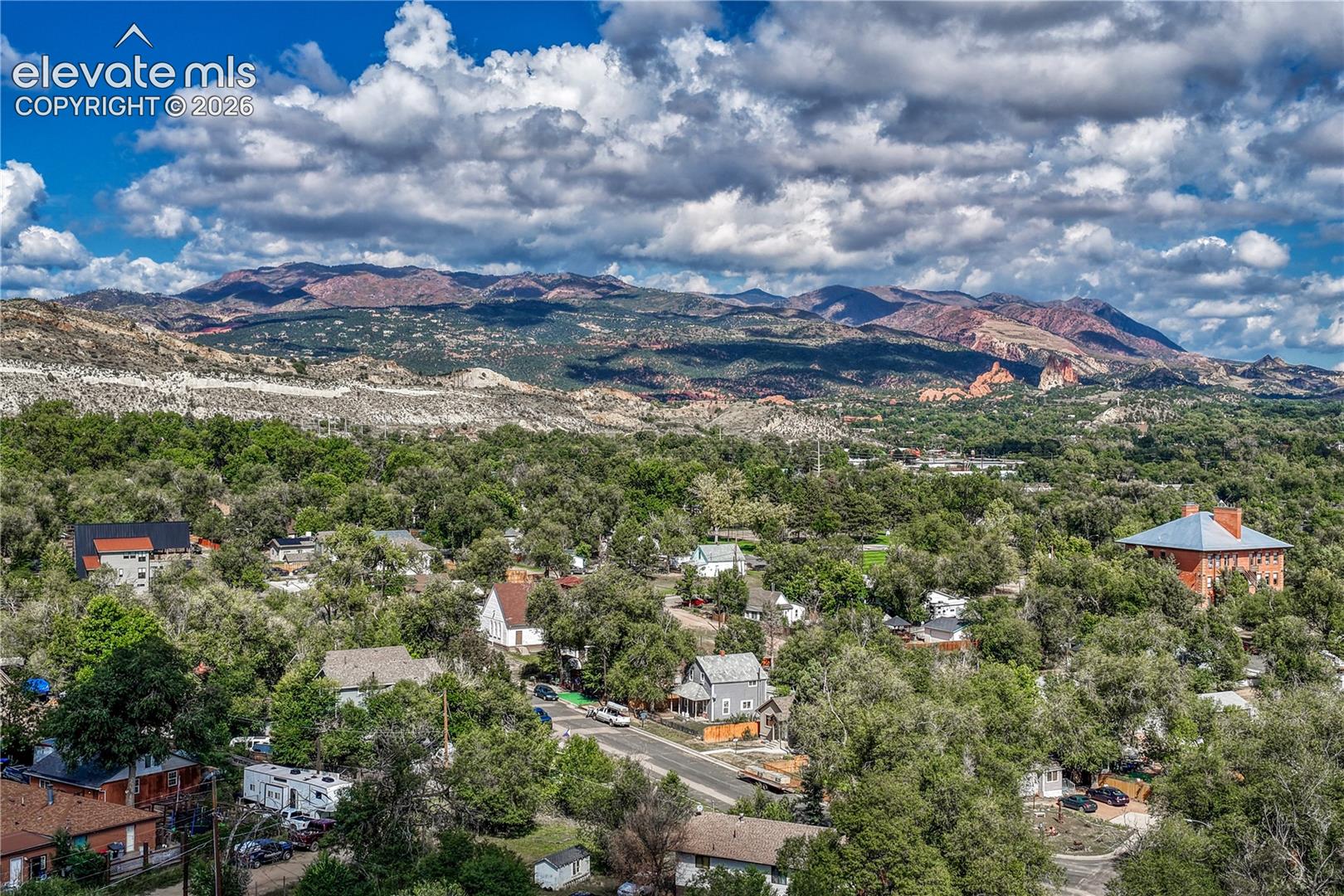 Expansive mountain backdrop with a tree-canopied neighborhood