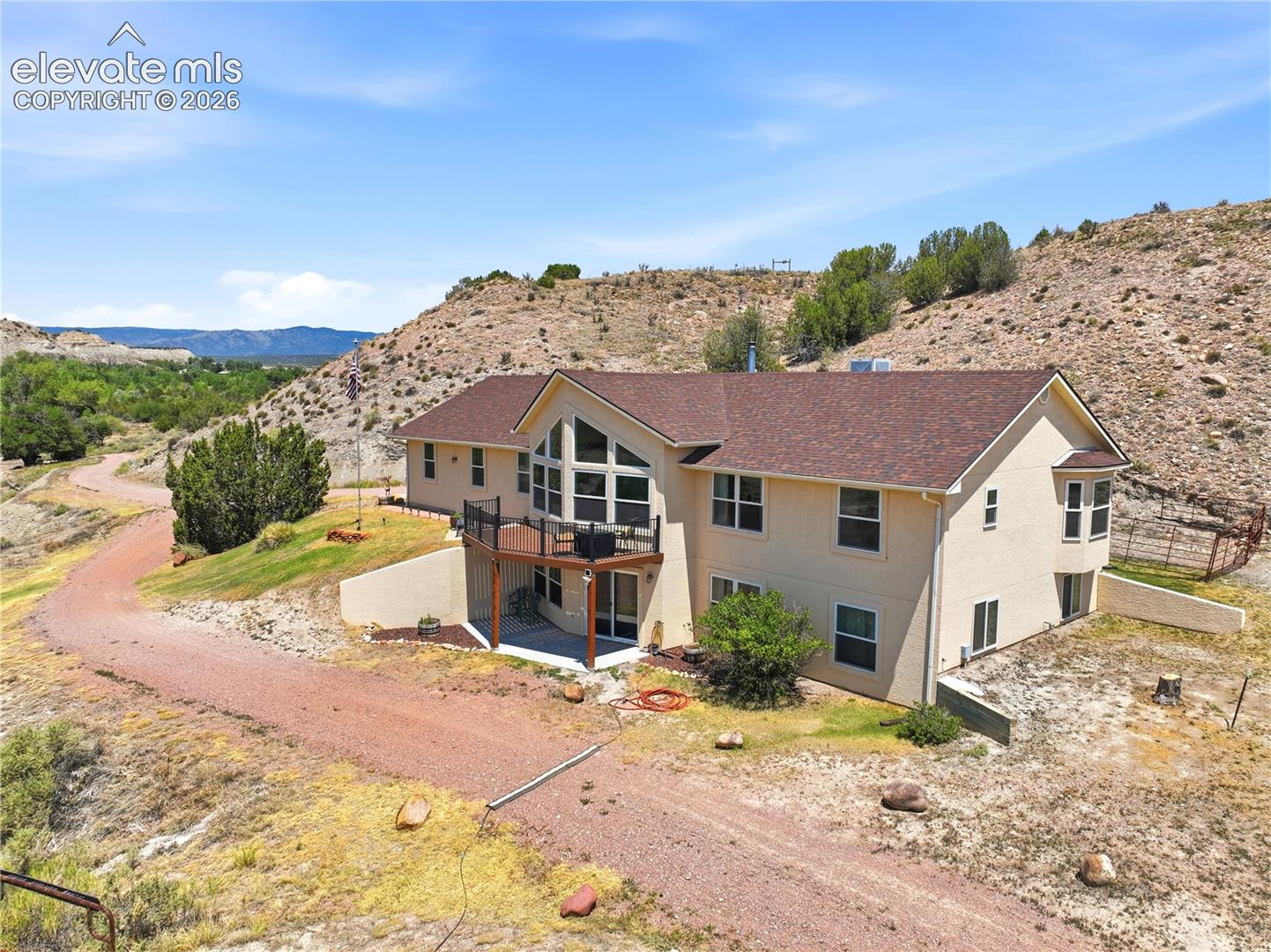 Multi-level residence featuring a prominent balcony, bay window, and expansive window wall