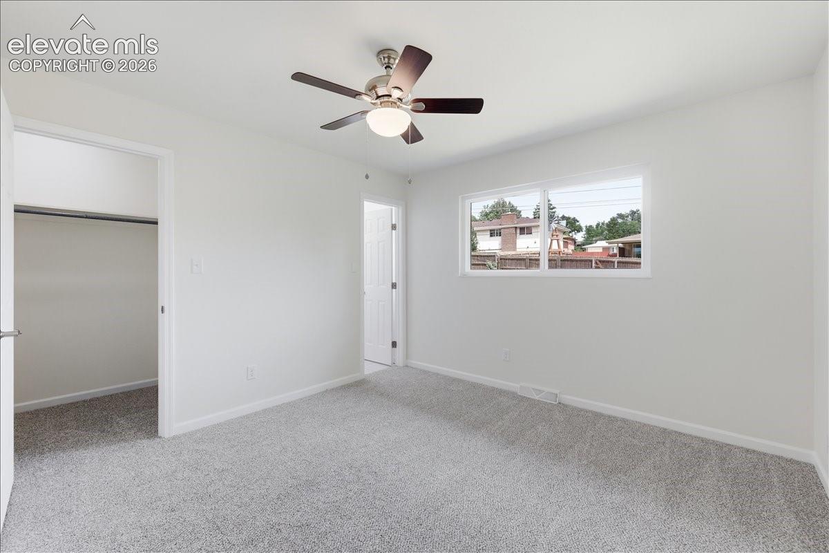 Main level primary bedroom with walk-in closet and attached bathroom.