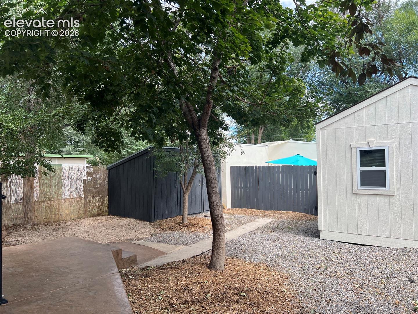 Main House Fenced yard with stamped concrete patio, pea gravel patio, dark-stained privacy fence, dark-stained storage shed and large workshop/shed. Cottage is fenced off privately