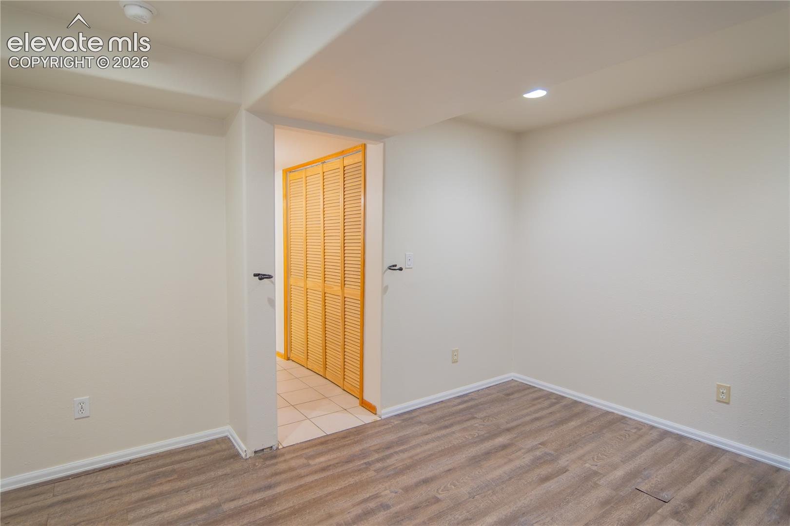 Additional view of the basement bedroom, featuring neutral finishes and closet storage.