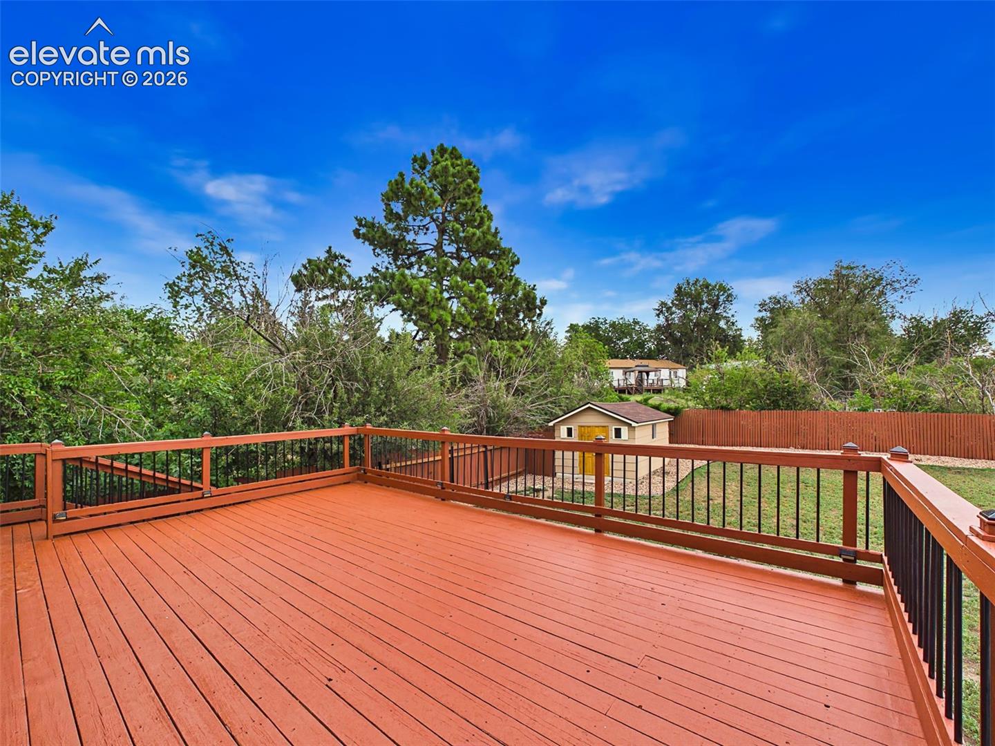 Expansive deck offers plenty of space for gatherings while enjoying views of the backyard and surrounding mature trees.