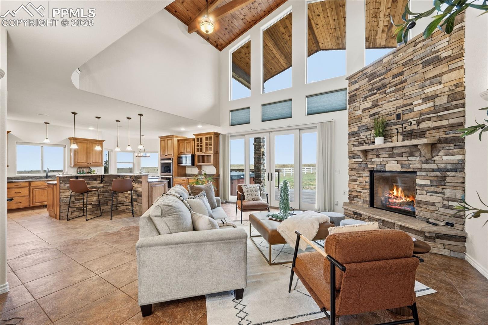 Stone fireplace extends up, ceramic tile floor, 2 story great room