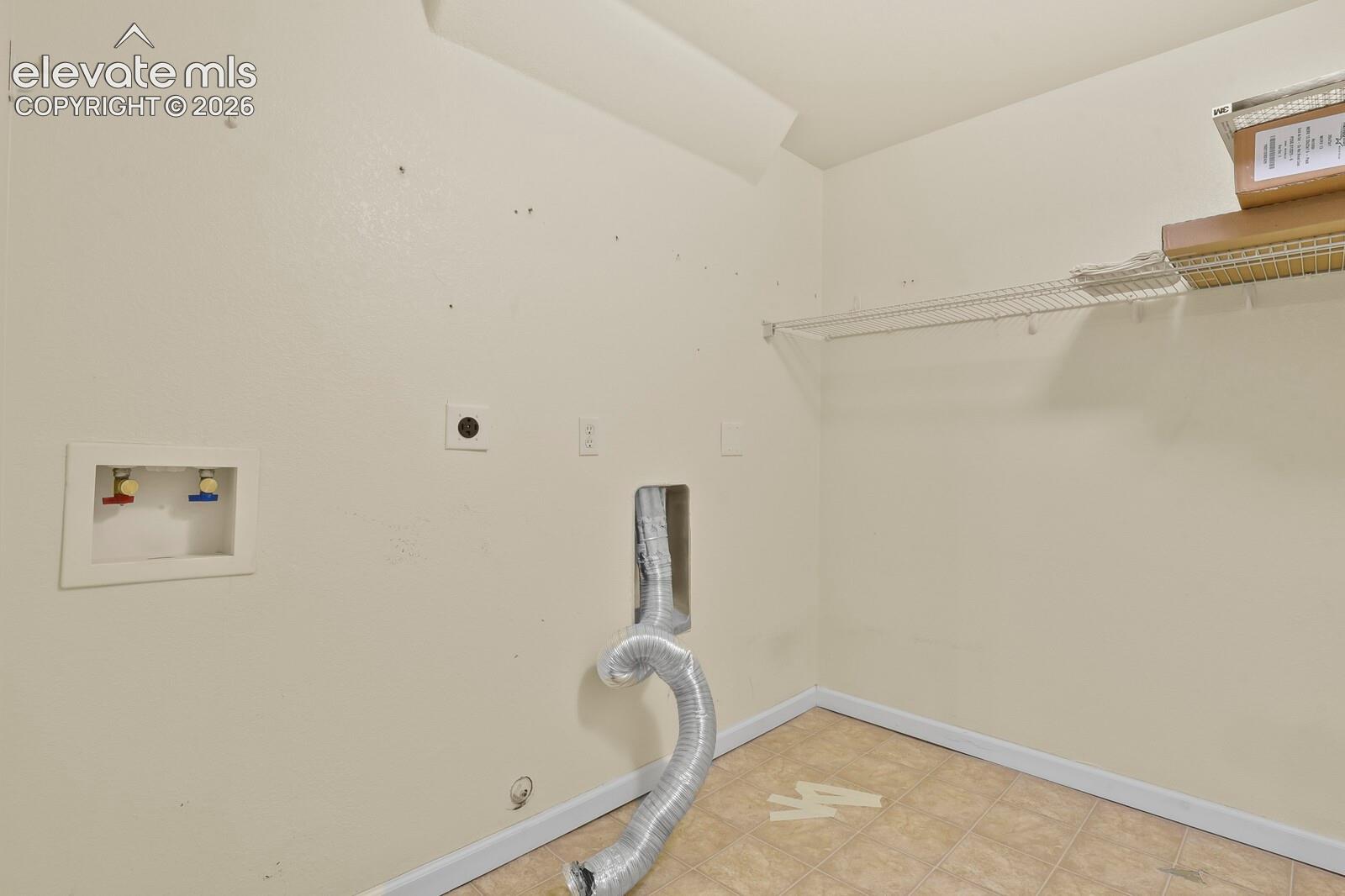Utility area featuring tile flooring, and white wire shelf