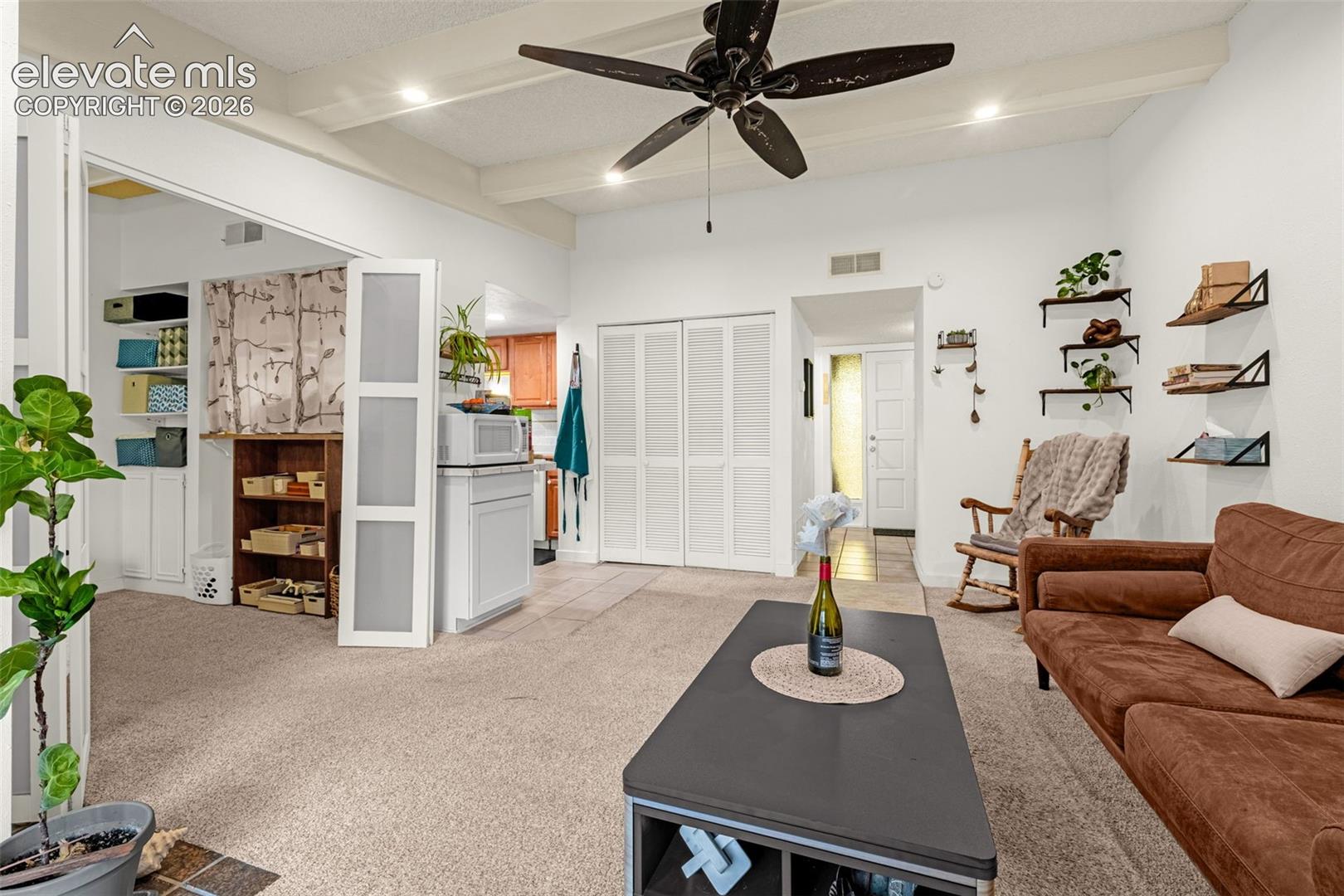 Vaulted ceiling with exposed beams, ceiling fan, recessed lighting, carpet flooring, and bi-fold closet doors