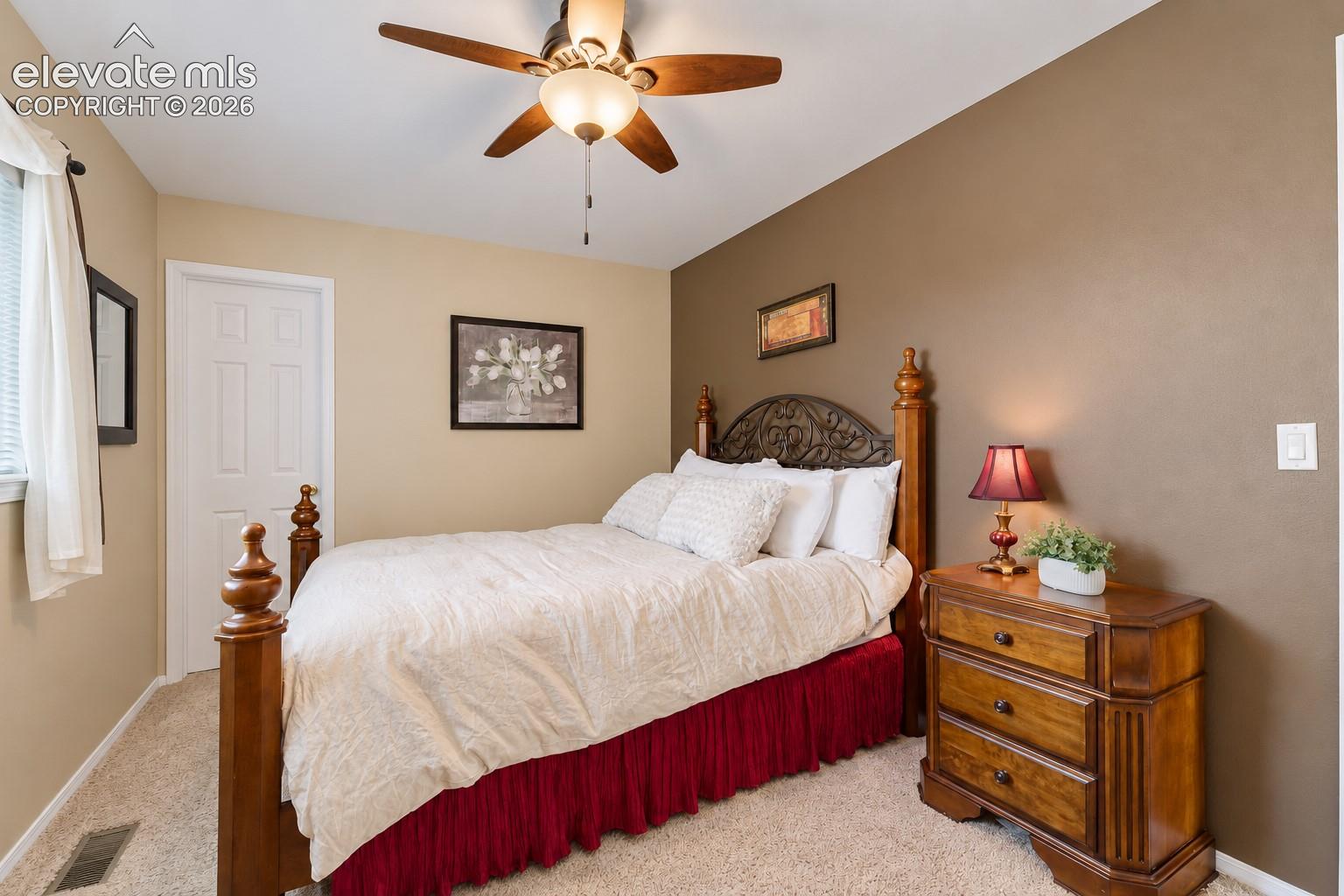 Upper Level Bedroom with walk in closet, lighted ceiling fan and neutral carpet.