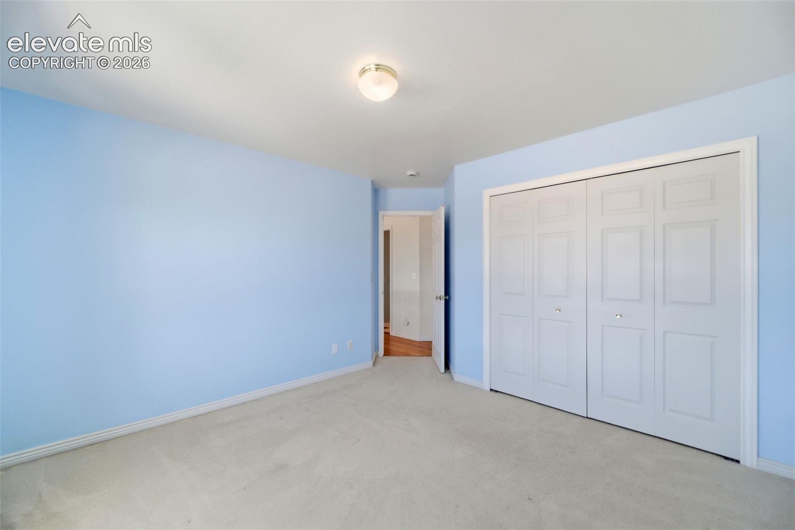 Carpeted room with light blue walls and white trim