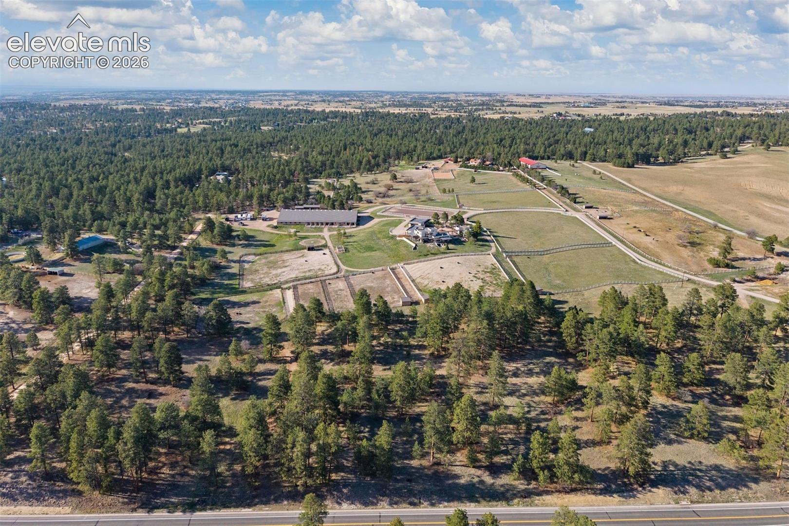 Overview of the 40 acres - A gravel driveway wraps the property, connecting the residence, stables, and arenas in one continuous, well-designed loop. 