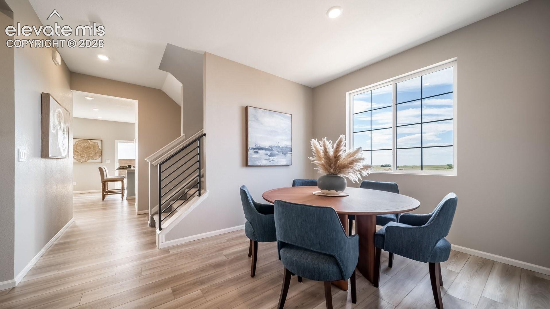Window with grid pattern, wood-finish flooring, recessed lighting, and a modern stair railing
*photos of a model home*