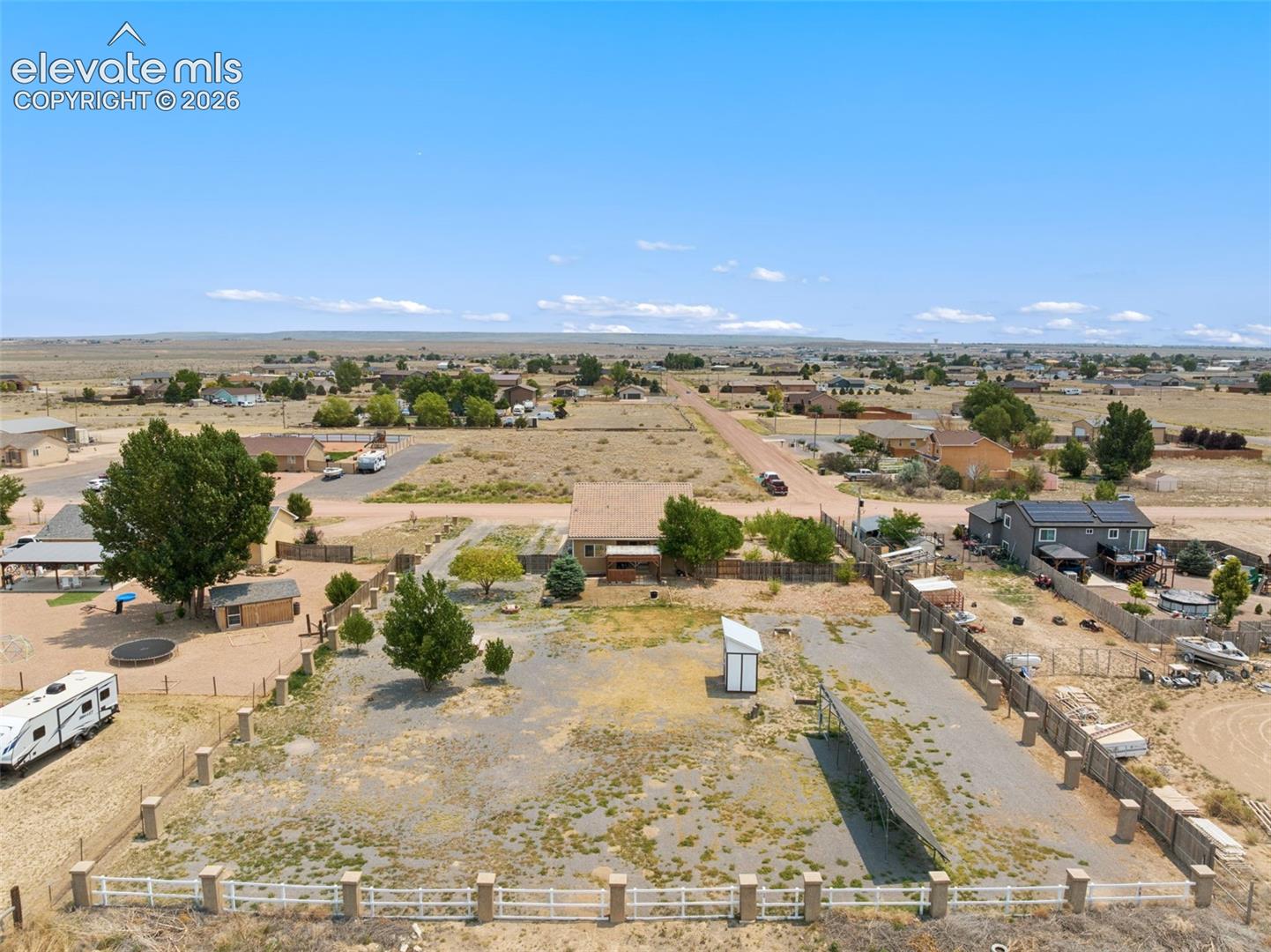 Expansive lot featuring perimeter fencing with concrete pillars and established mature trees