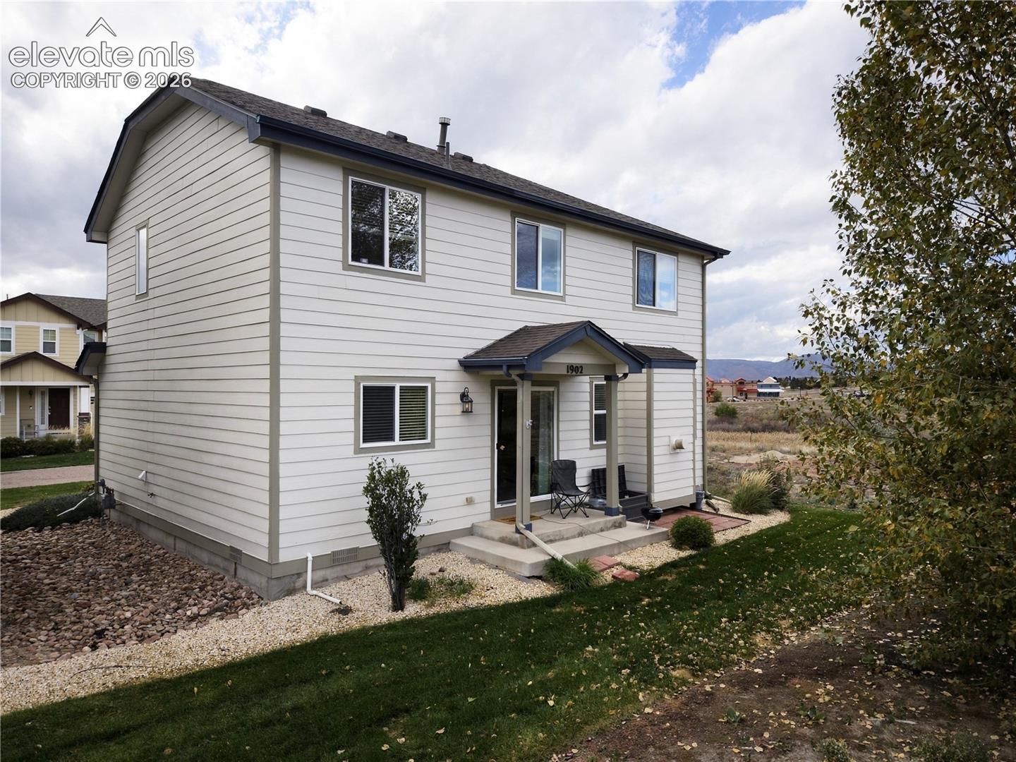 Two-story exterior featuring horizontal siding, a covered entryway, and a concrete patio
