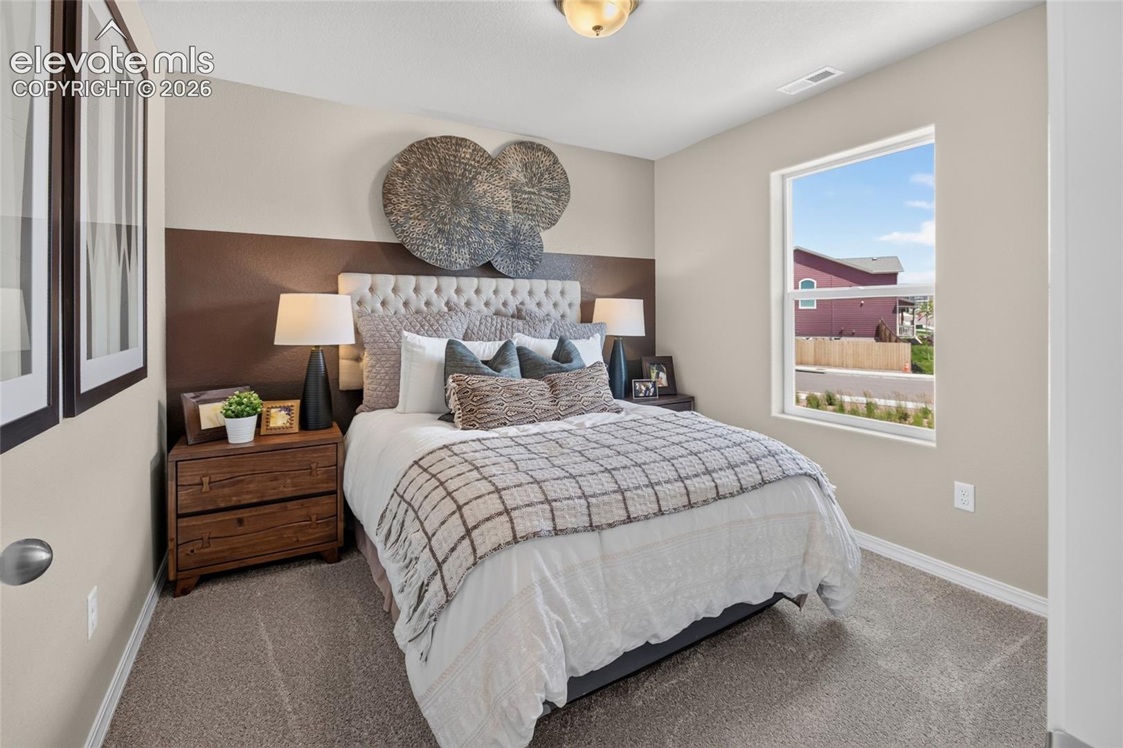 Interior room featuring neutral-toned carpeting, two-toned wall paint, and a single-pane window