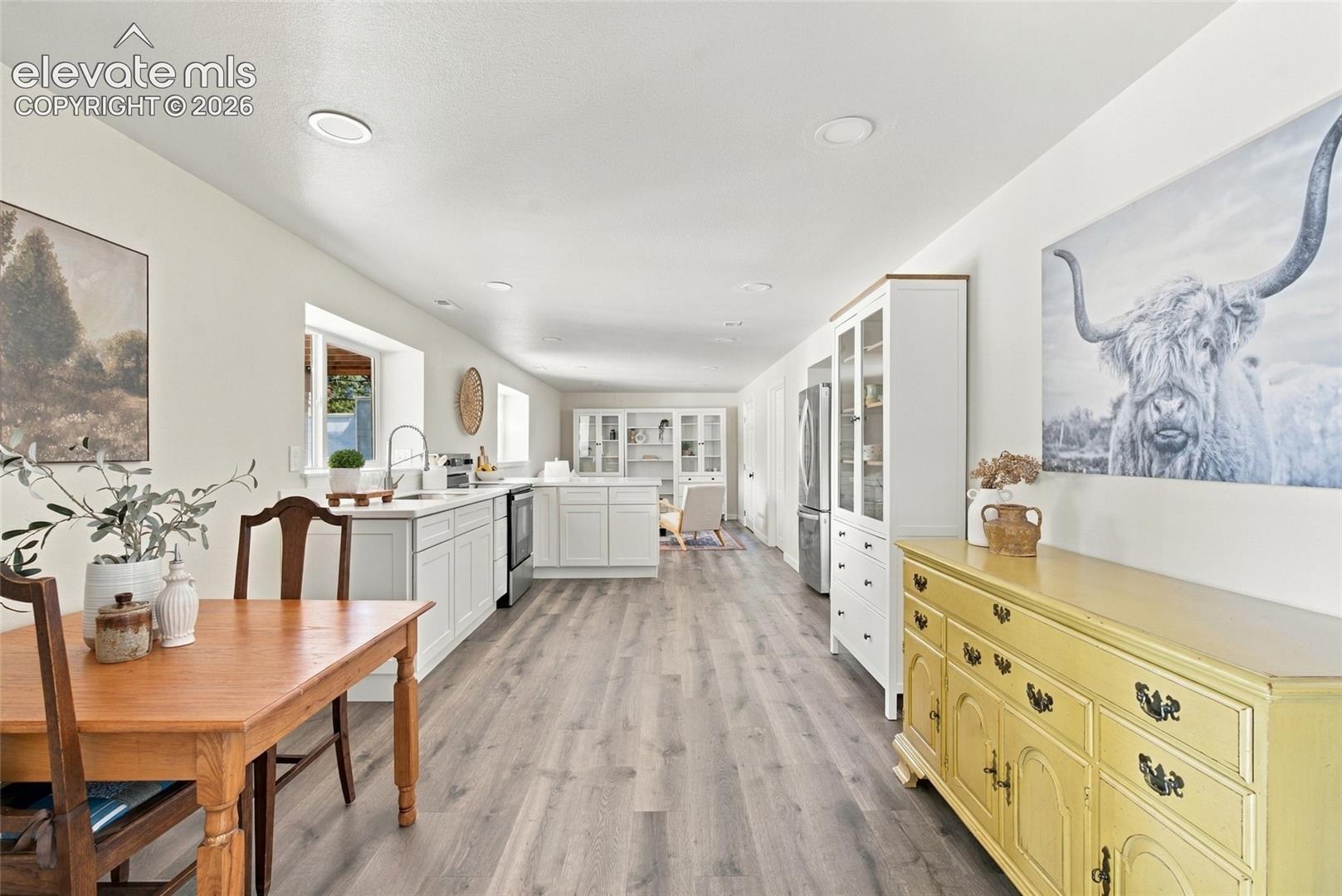 Basement Open-concept second kitchen with white cabinetry, stainless steel appliances, and a central island