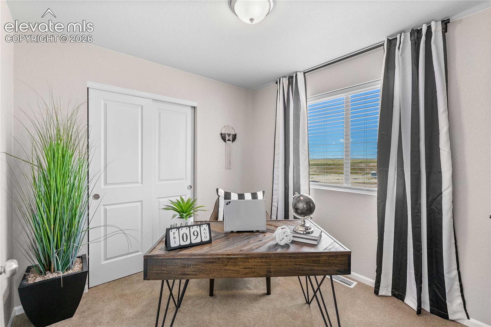 Recessed ceiling light, light-colored carpeting, white sliding closet doors, window with blinds, and white trim
*photos of a model home*