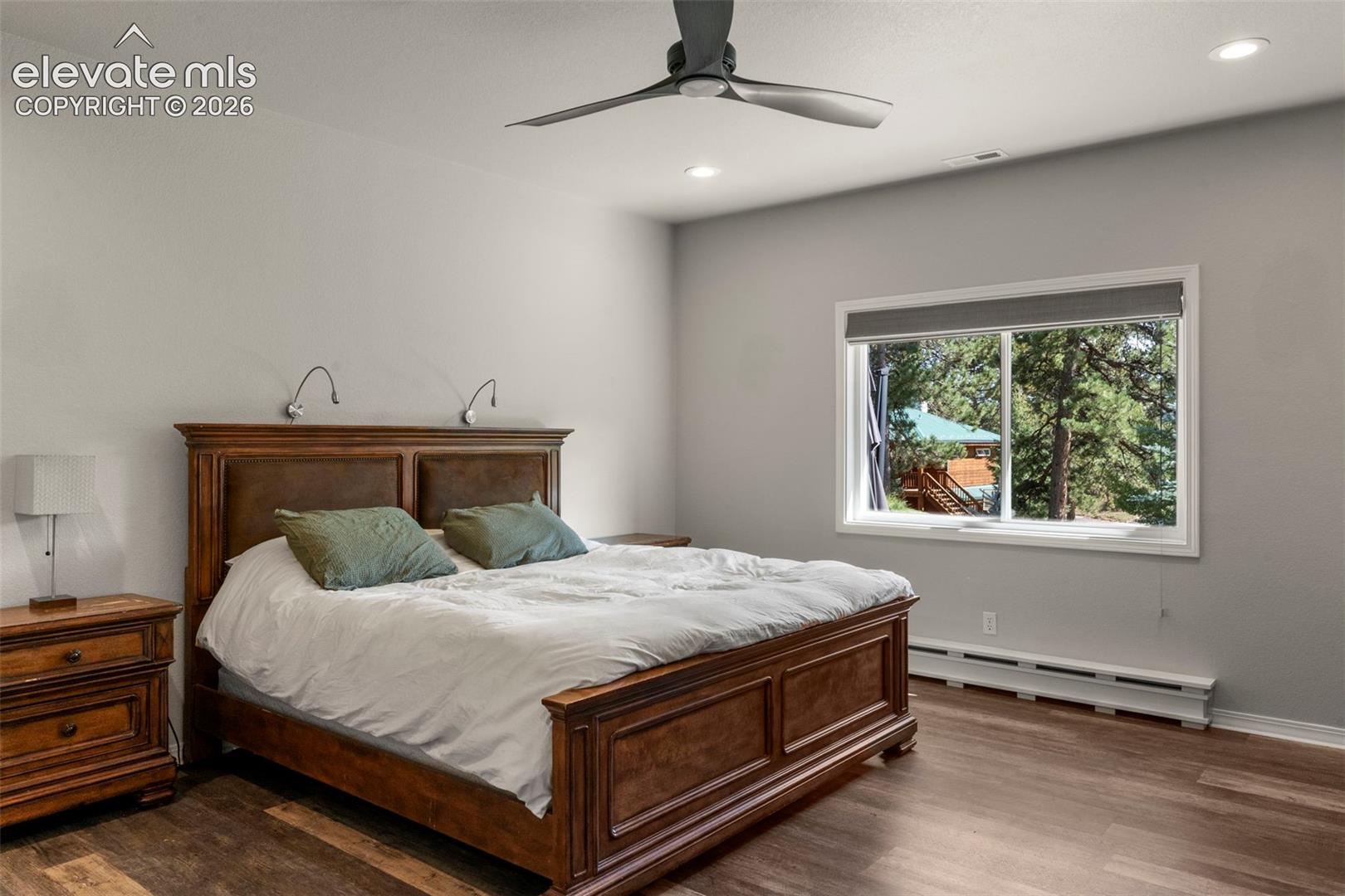 Bedroom with a baseboard heating unit, dark wood-style flooring, a ceiling fan, and recessed lighting