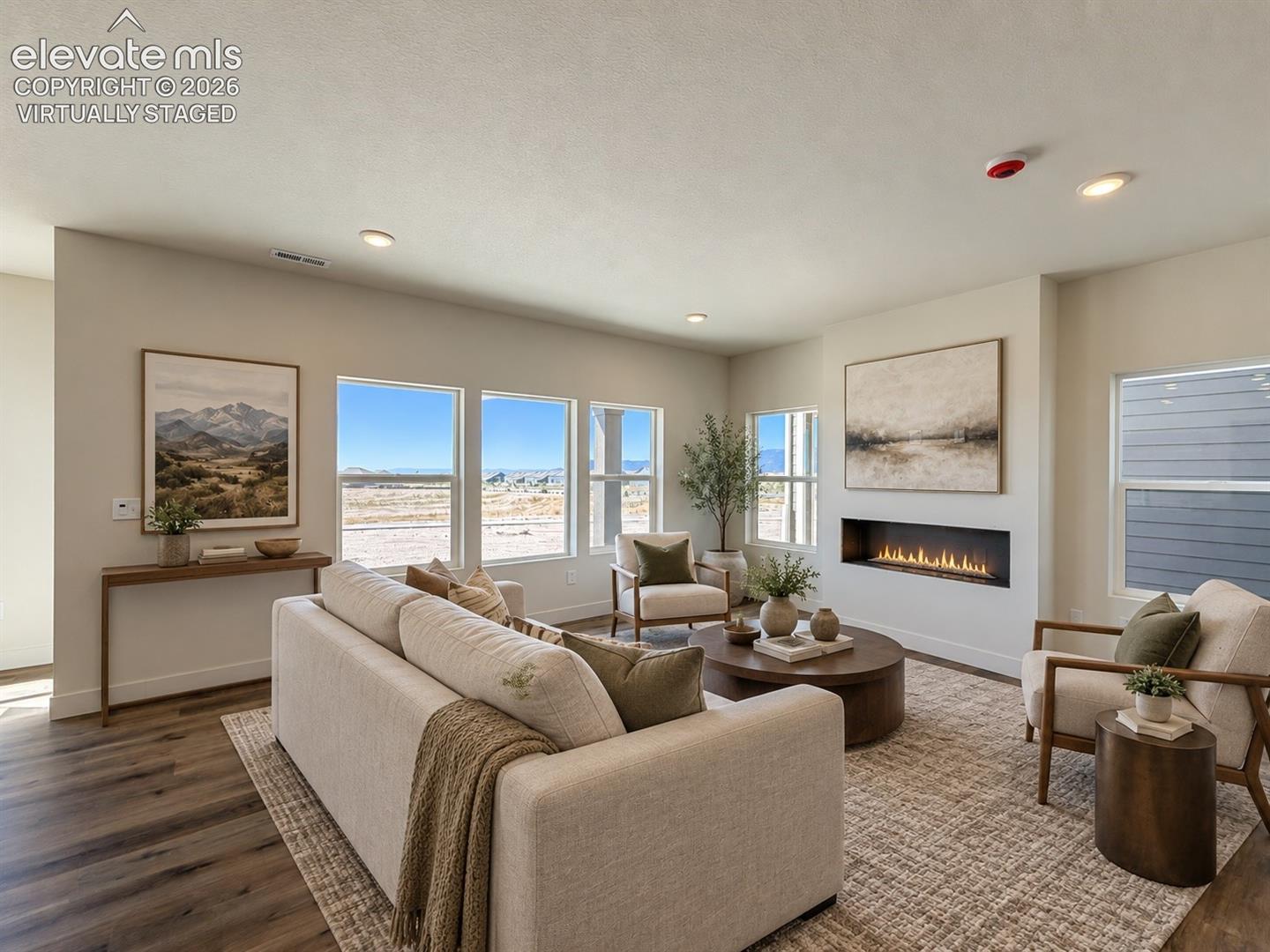 living room with linear fireplace, three adjacent windows, neutral furnishings, and contemporary art — virtually staged