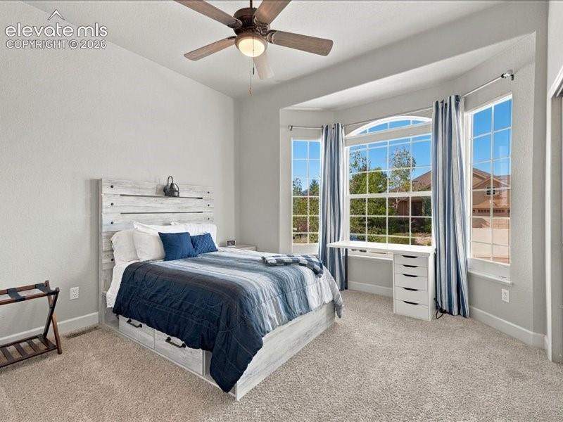 Bay window with an arched transom, recessed lighting, ceiling fan, and carpeted flooring