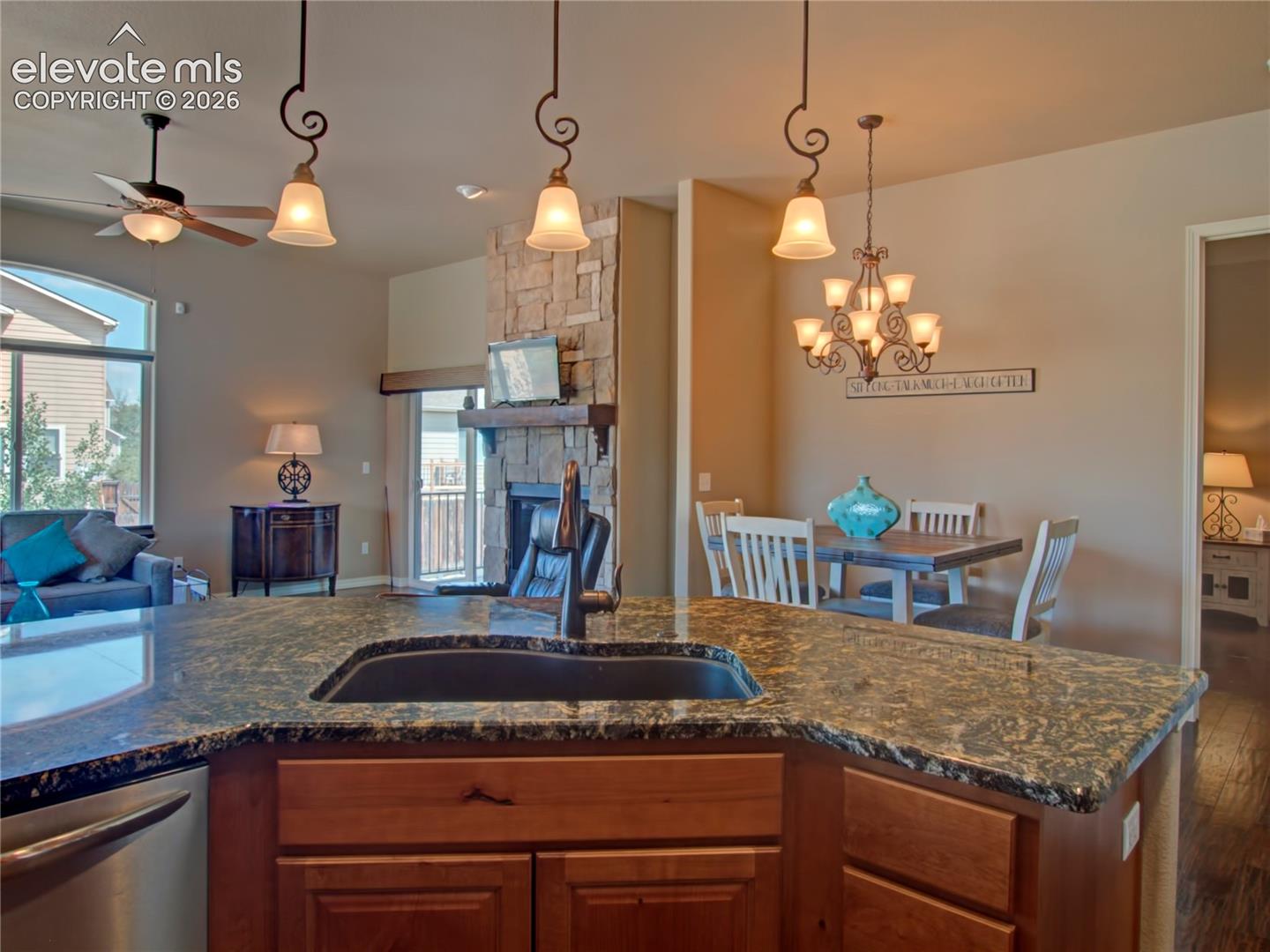 Kitchen island featuring a dark granite countertop with an integrated sink and a dark faucet