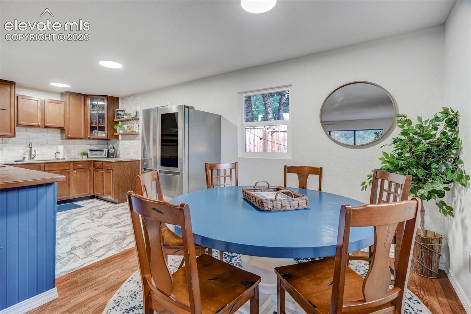 Kitchen featuring wood-finish cabinetry, tile backsplash, and stainless steel refrigerator