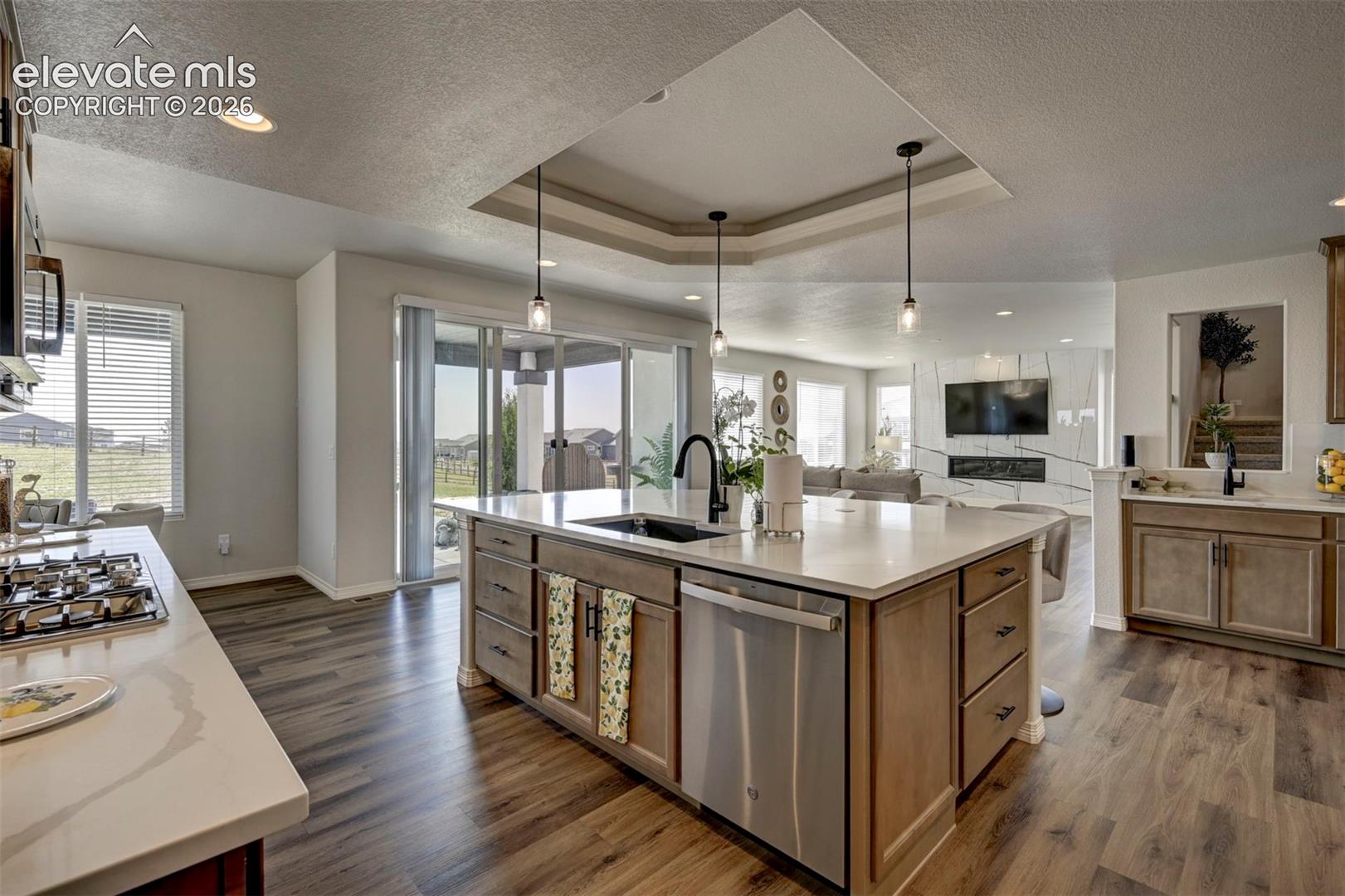Kitchen featuring a large central island with a built-in sink and stainless steel dishwasher