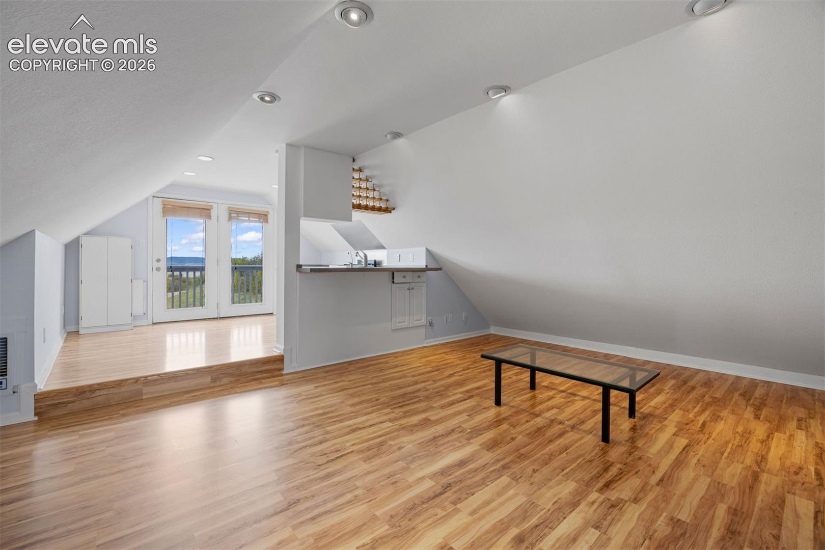 Non conforming ADU with open living area with vaulted ceiling, kitchen, and French door walk-out to private deck.