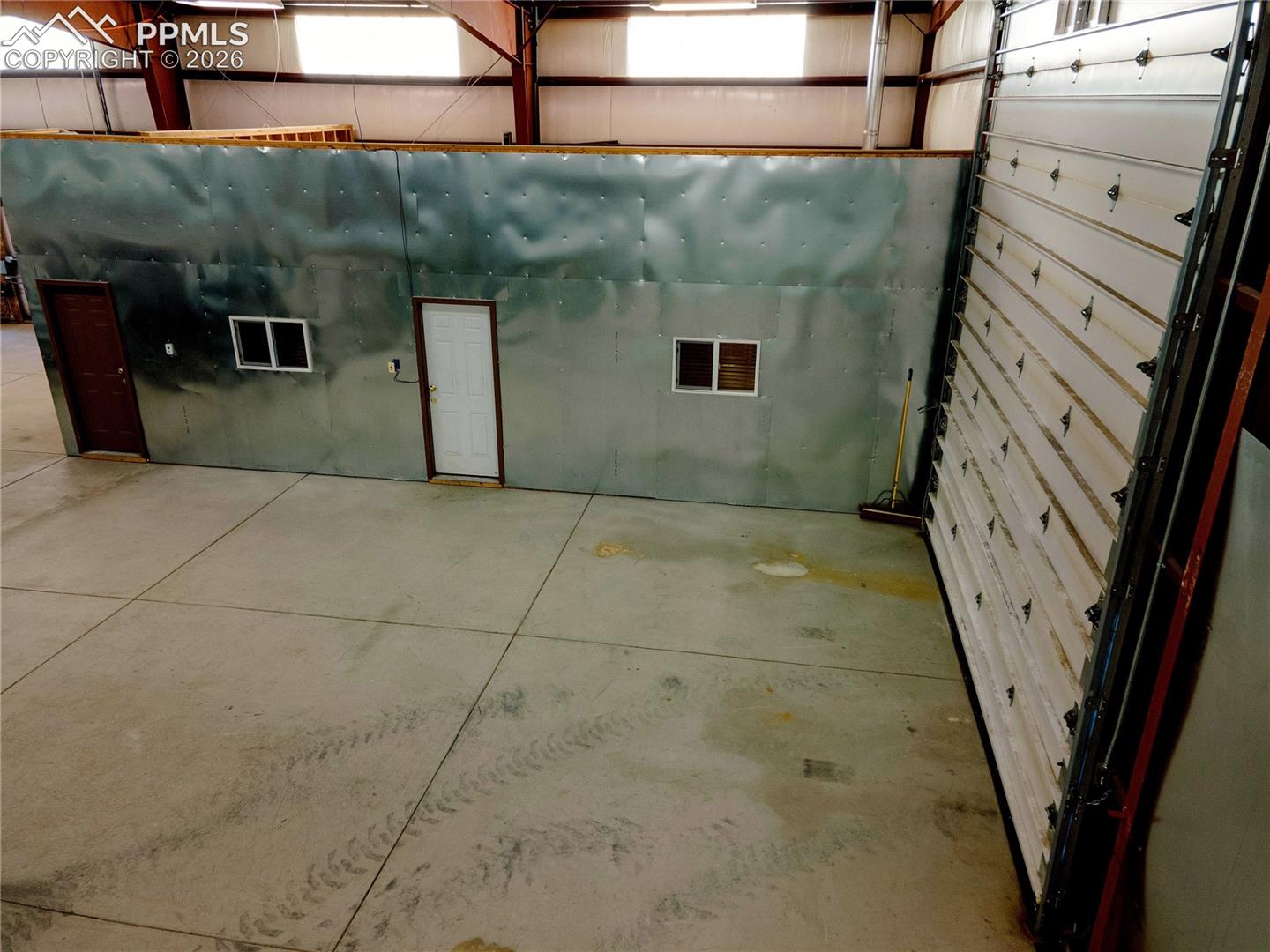 The property features a spacious interior with concrete flooring and exposed structural beams