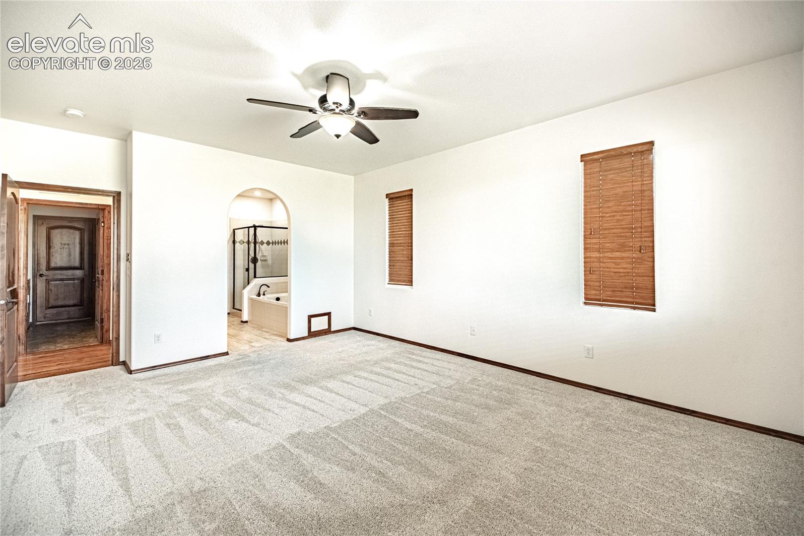 Spacious room featuring light-toned carpeting and white walls