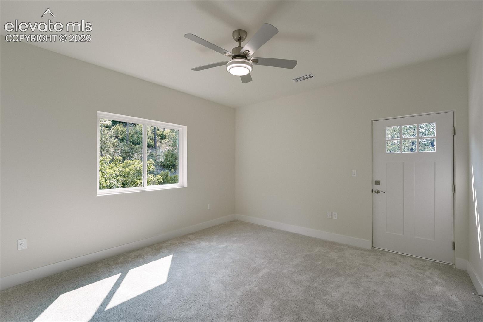 Upper Level Bedroom #4 with neutral carpet,  a lighted ceiling fan, and walk out to a balcony.