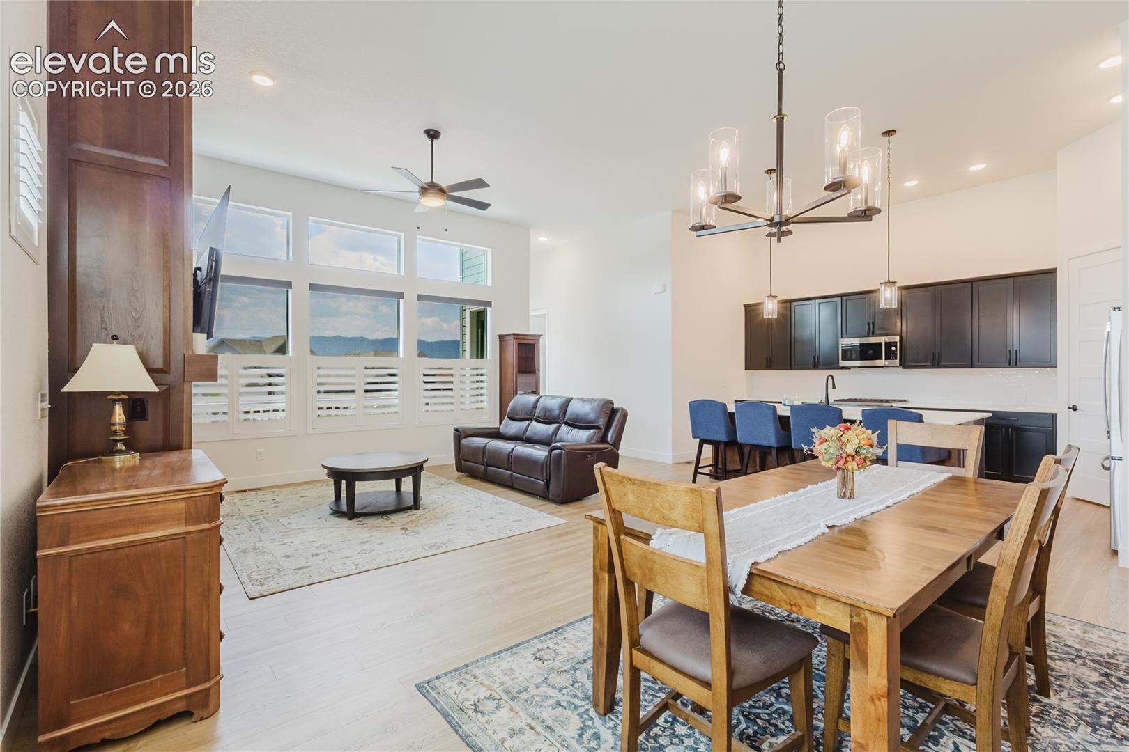 Open-concept living space featuring high ceilings custome woodwork to match the library and contemporary chandelier