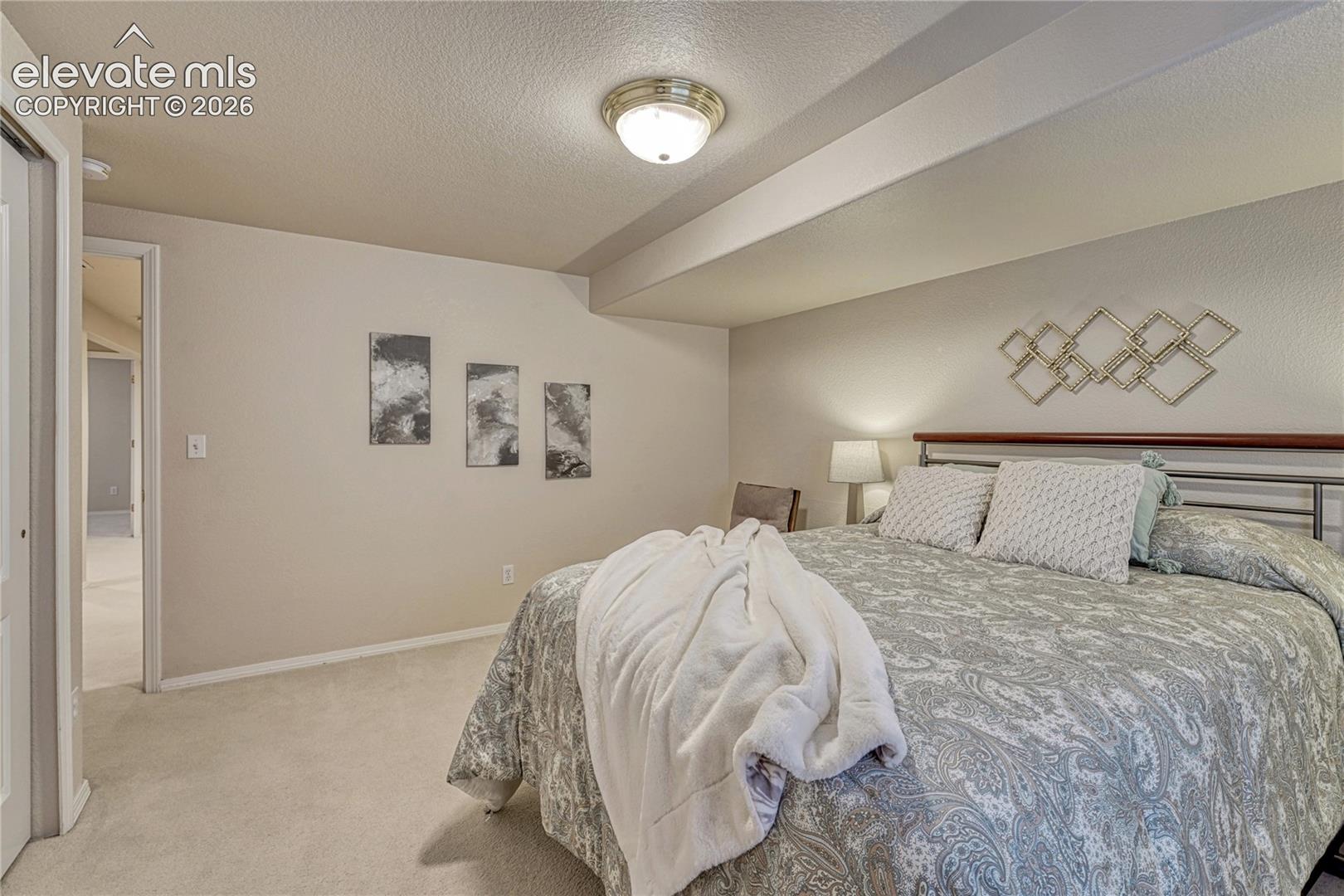 Clean neutral wall paint and plush carpeting create a restful guest retreat in this lower-level bedroom
