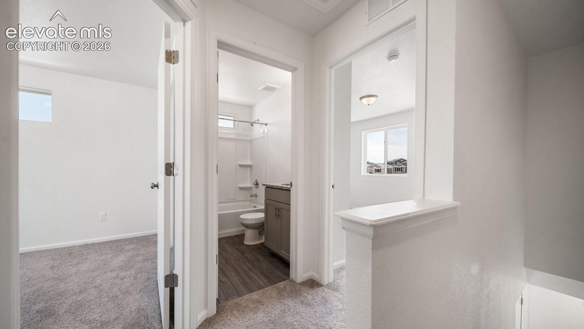 Hallway featuring neutral carpeting, white walls, and bright white trim
*photos of a model home*