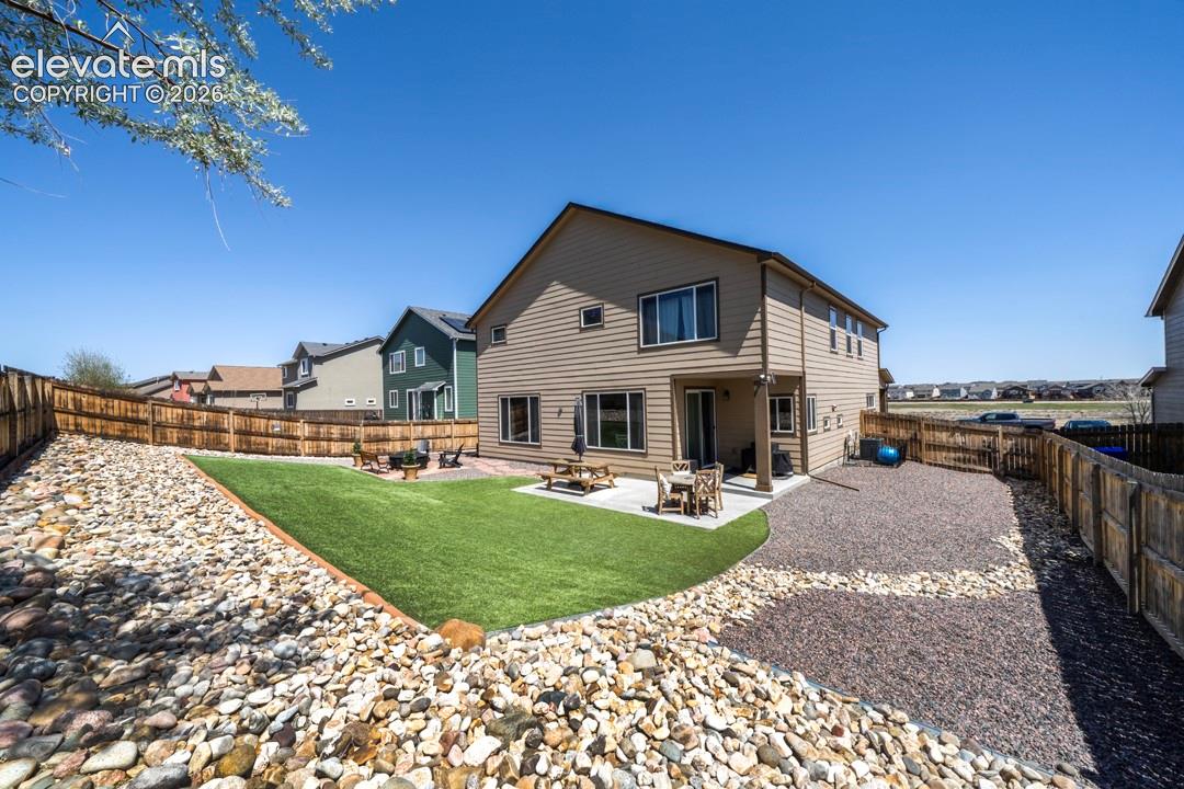 Backyard, astroturf, covered patio, firepit, flagstone walkway, storage shed