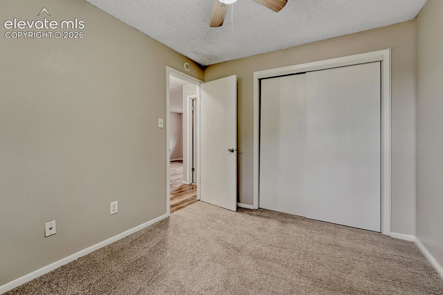 Textured wall finish, ceiling fan, and sliding closet doors