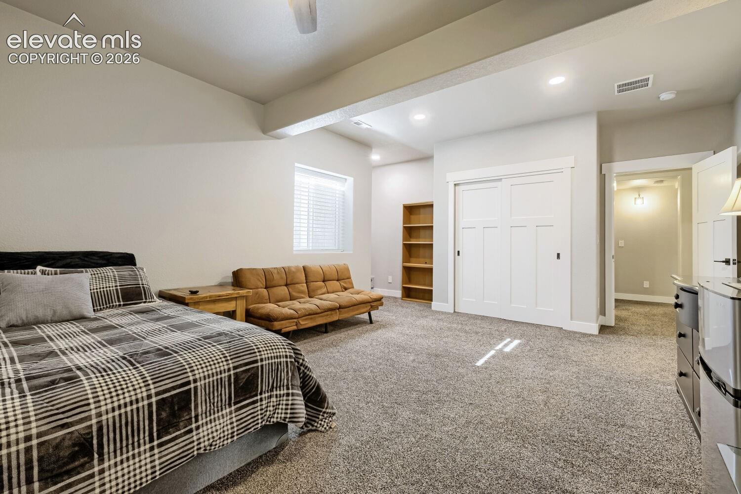 Recessed lighting, wood-finish shelving, textured carpeting, sliding panel closet doors, and overhead lighting