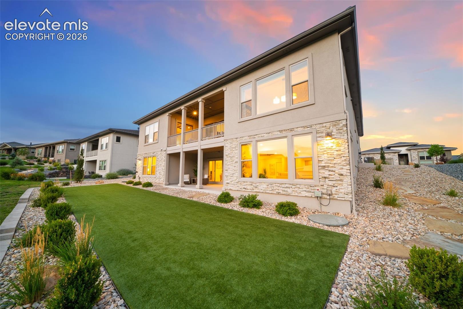 Multi-level exterior with stucco and stone cladding