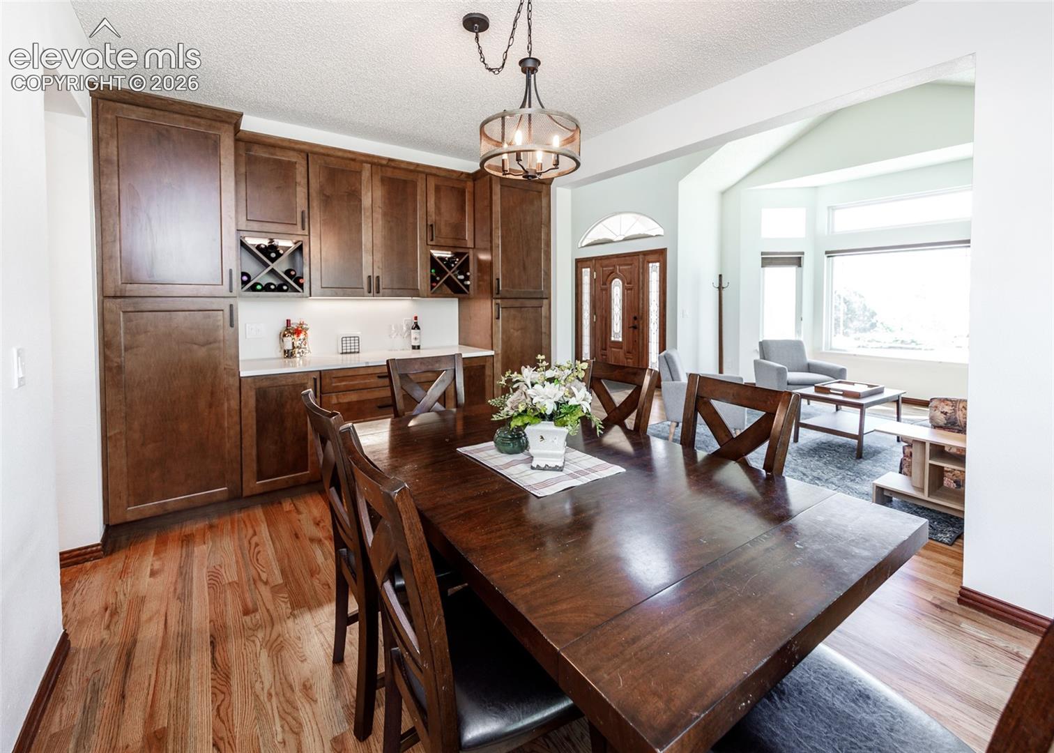 Hardwood flooring throughout, built-in cabinetry with wine storage, recessed lighting, and a bay window