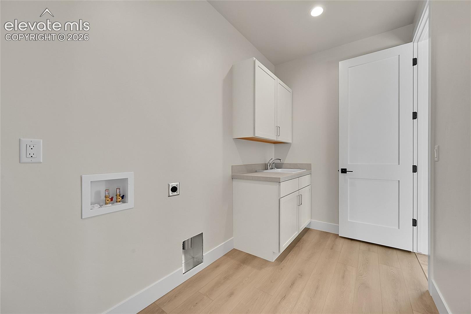 Laundry room featuring a built-in sink, main floor