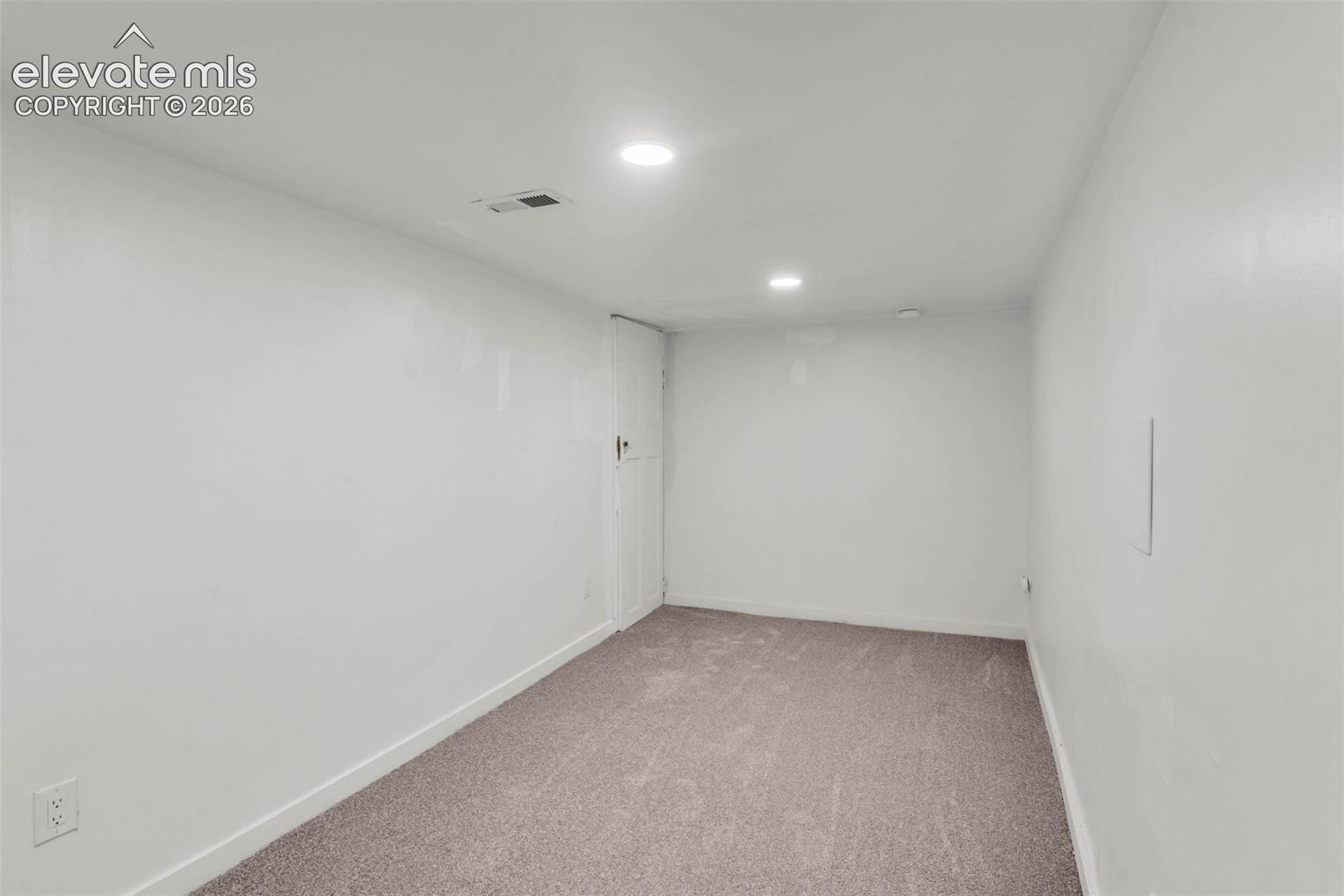 Neutral-toned carpeting, smooth-finish walls, and recessed ceiling lighting