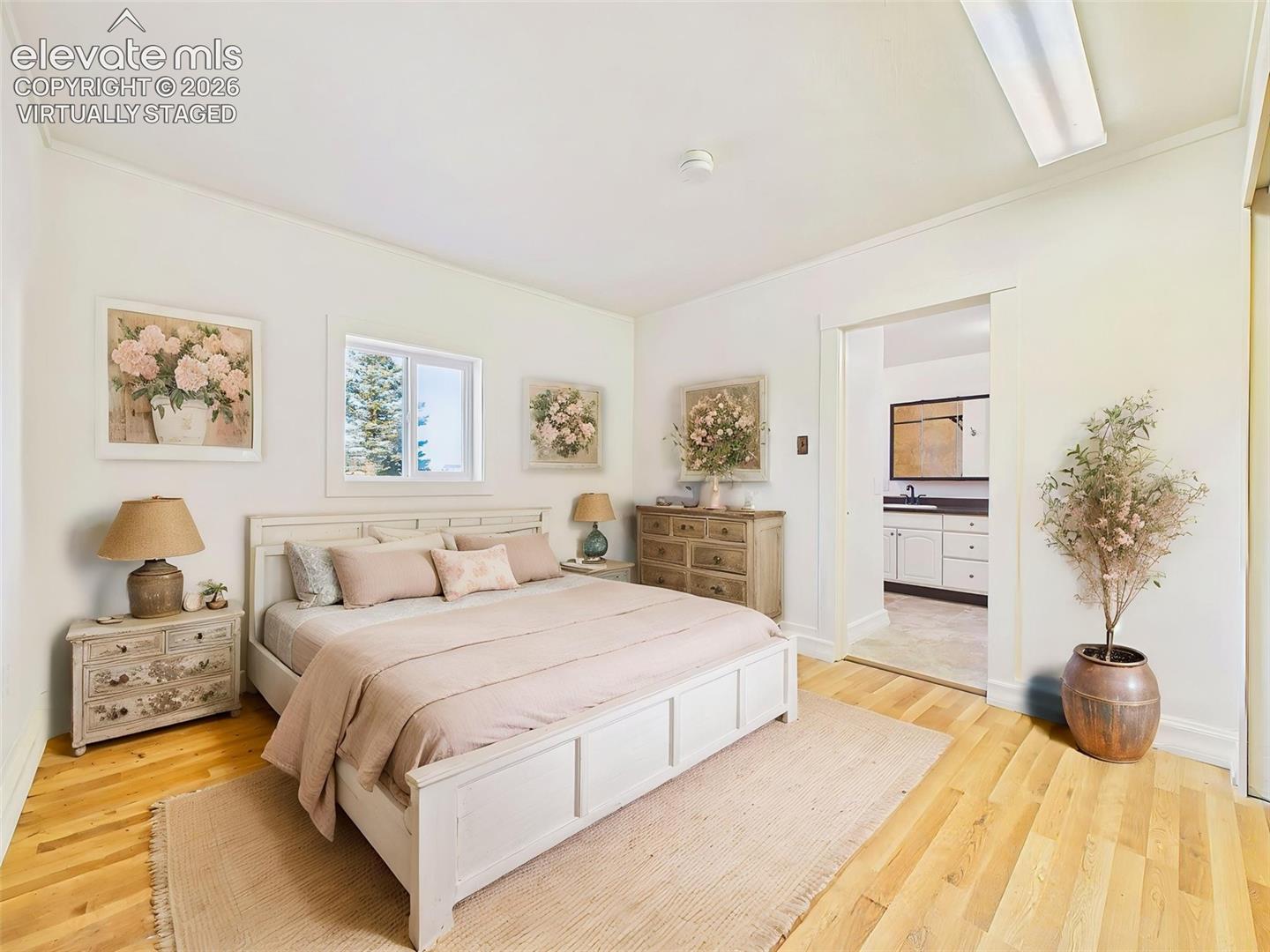 (Virtually Staged) Primary Bedroom – Spacious primary bedroom features hardwood flooring, abundant natural light, and direct access to the adjoining en-suite bathroom.