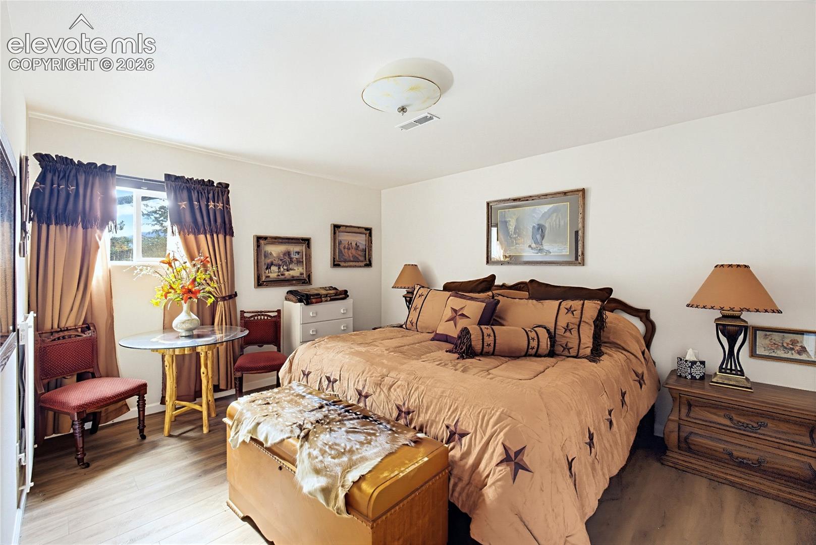 Neutral-toned walls, wood-finish flooring, and a flush-mount ceiling light fixture