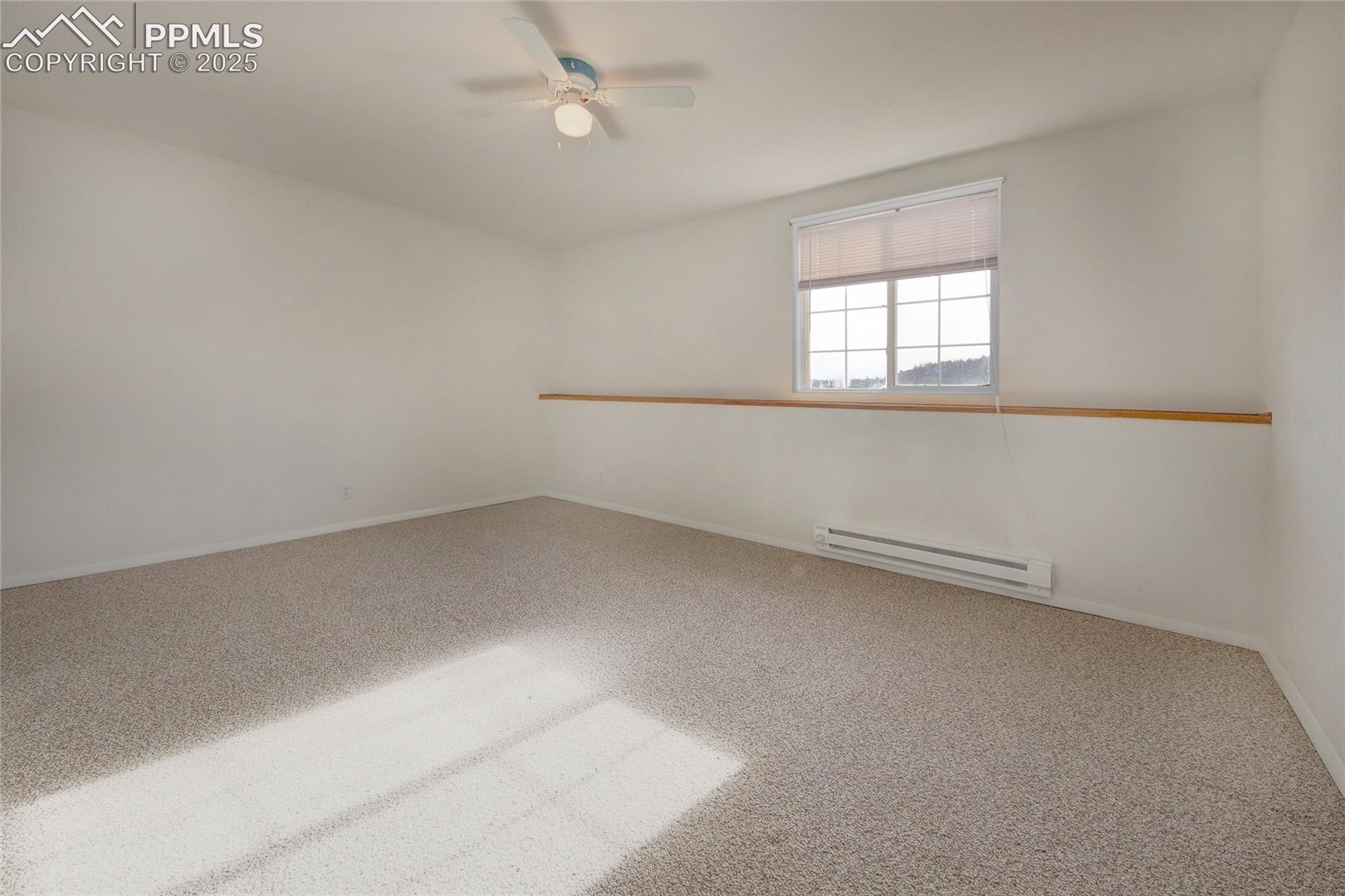 Bedroom 5 in basement with window ledge and ceiling fan