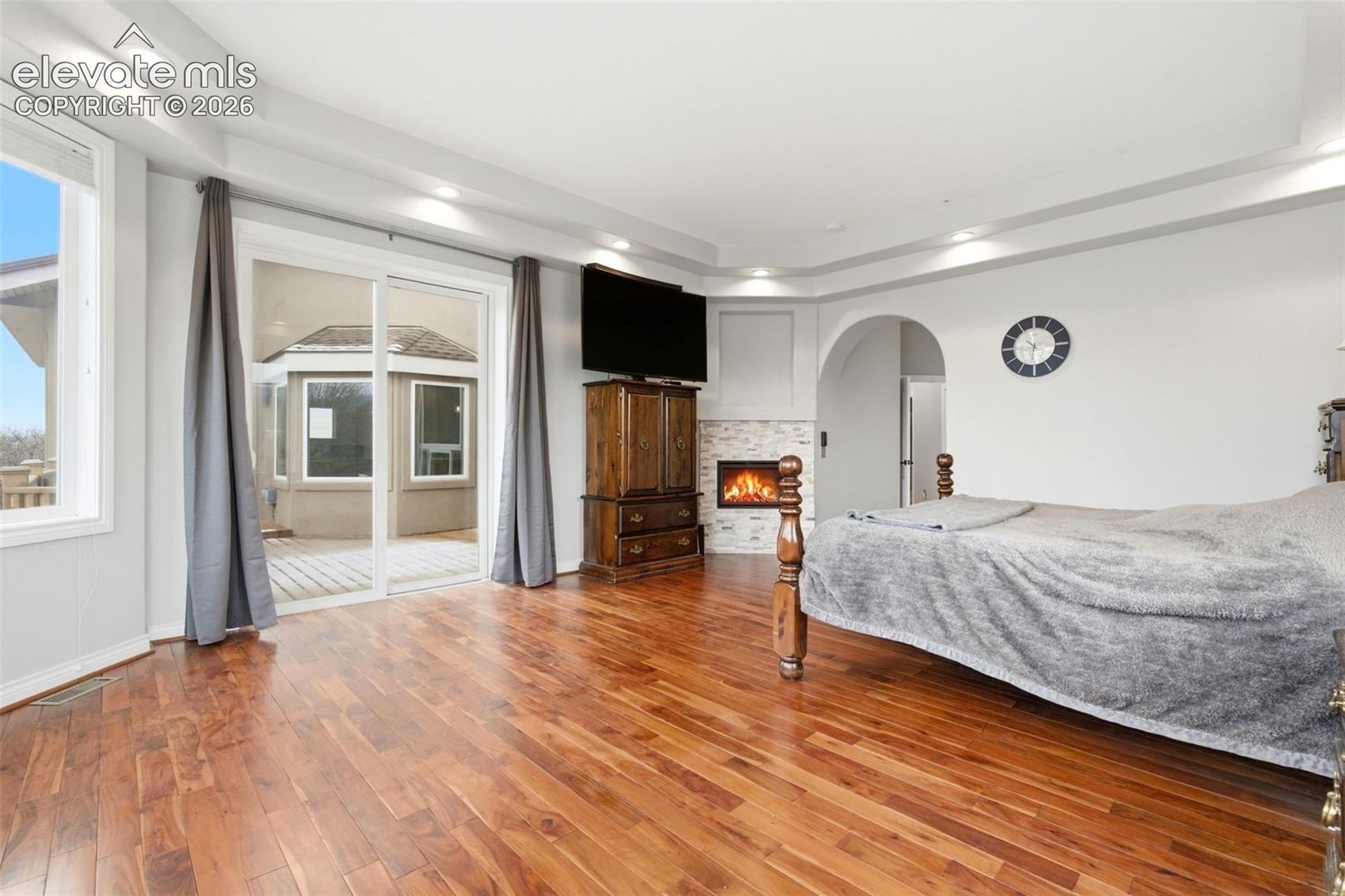 Wood-finish flooring, recessed lighting, and tray ceiling