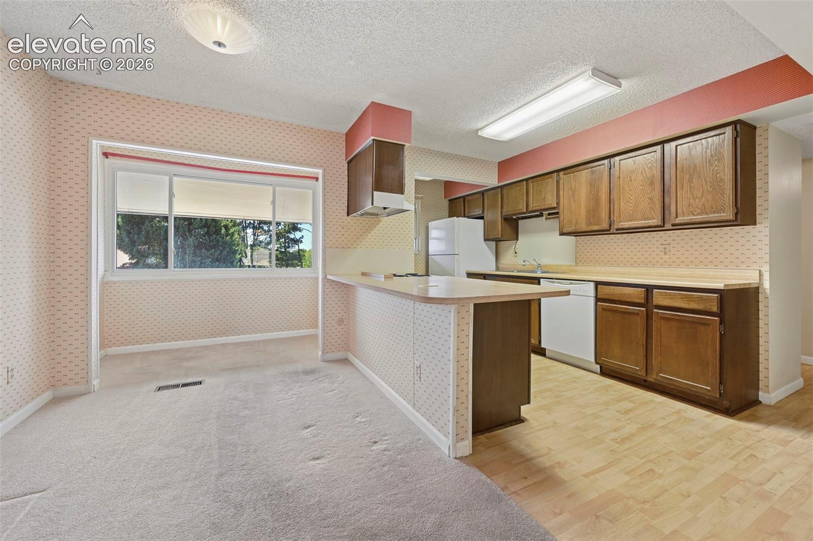 Kitchen with wood-finish flooring, wood cabinetry, and a breakfast bar