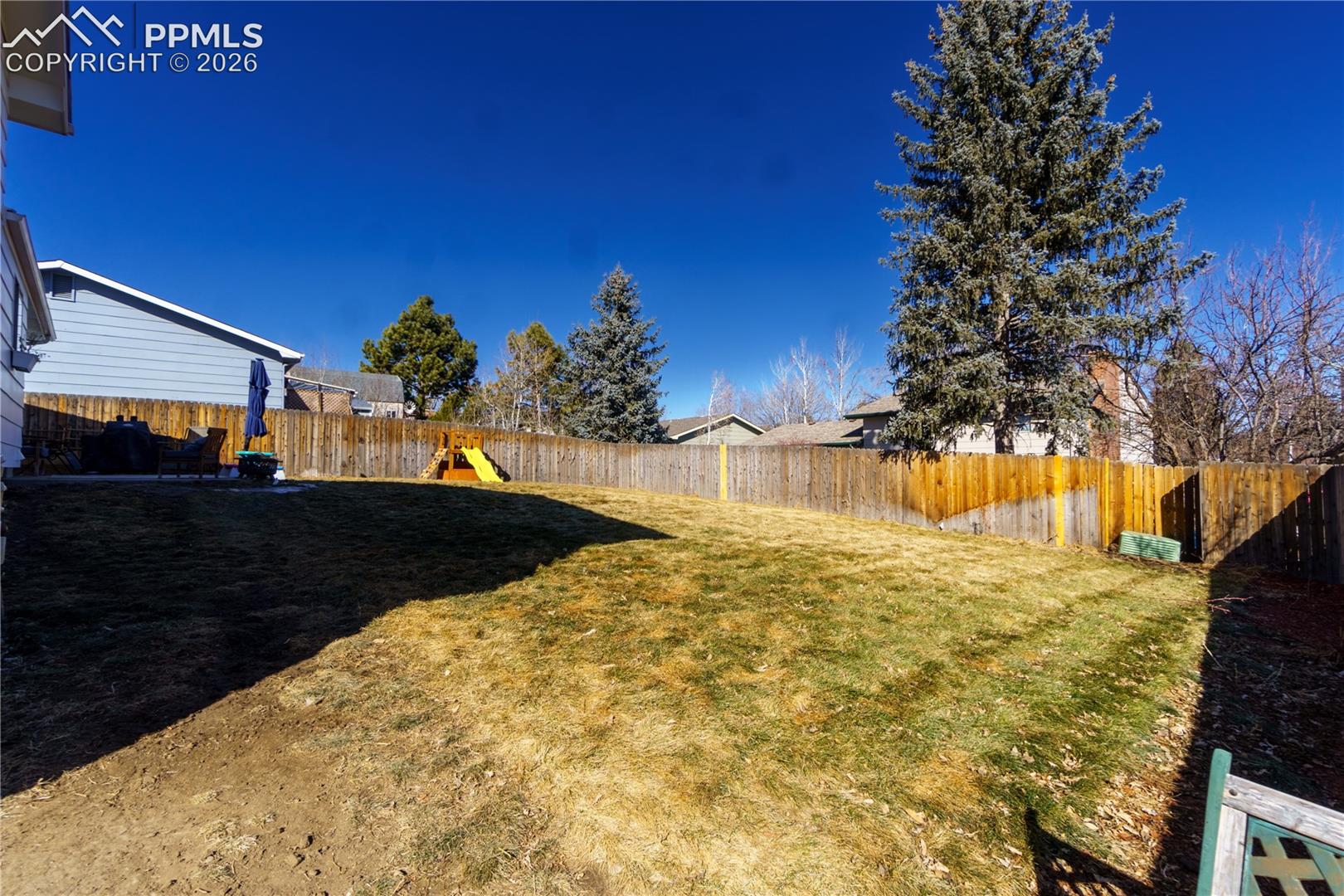 View of yard with a fenced backyard and a playground