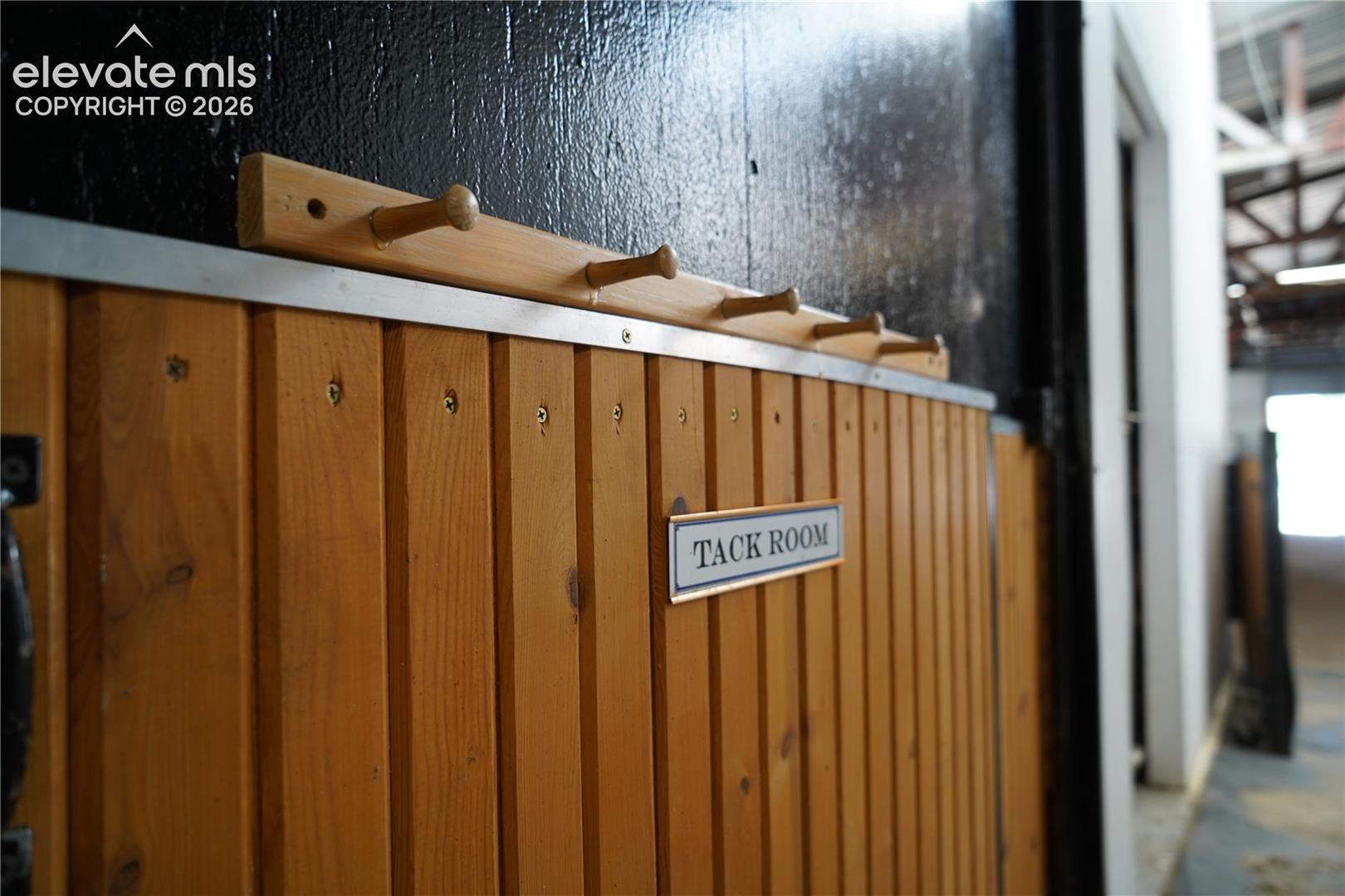 Wood-paneled room with a "Tack Room" sign