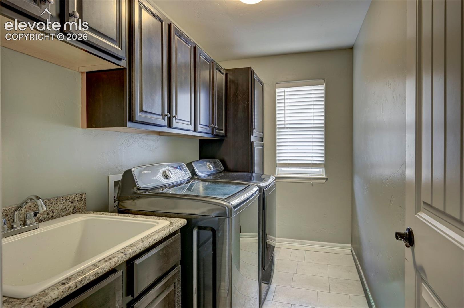 Upstairs laundry room with sink and cabinets